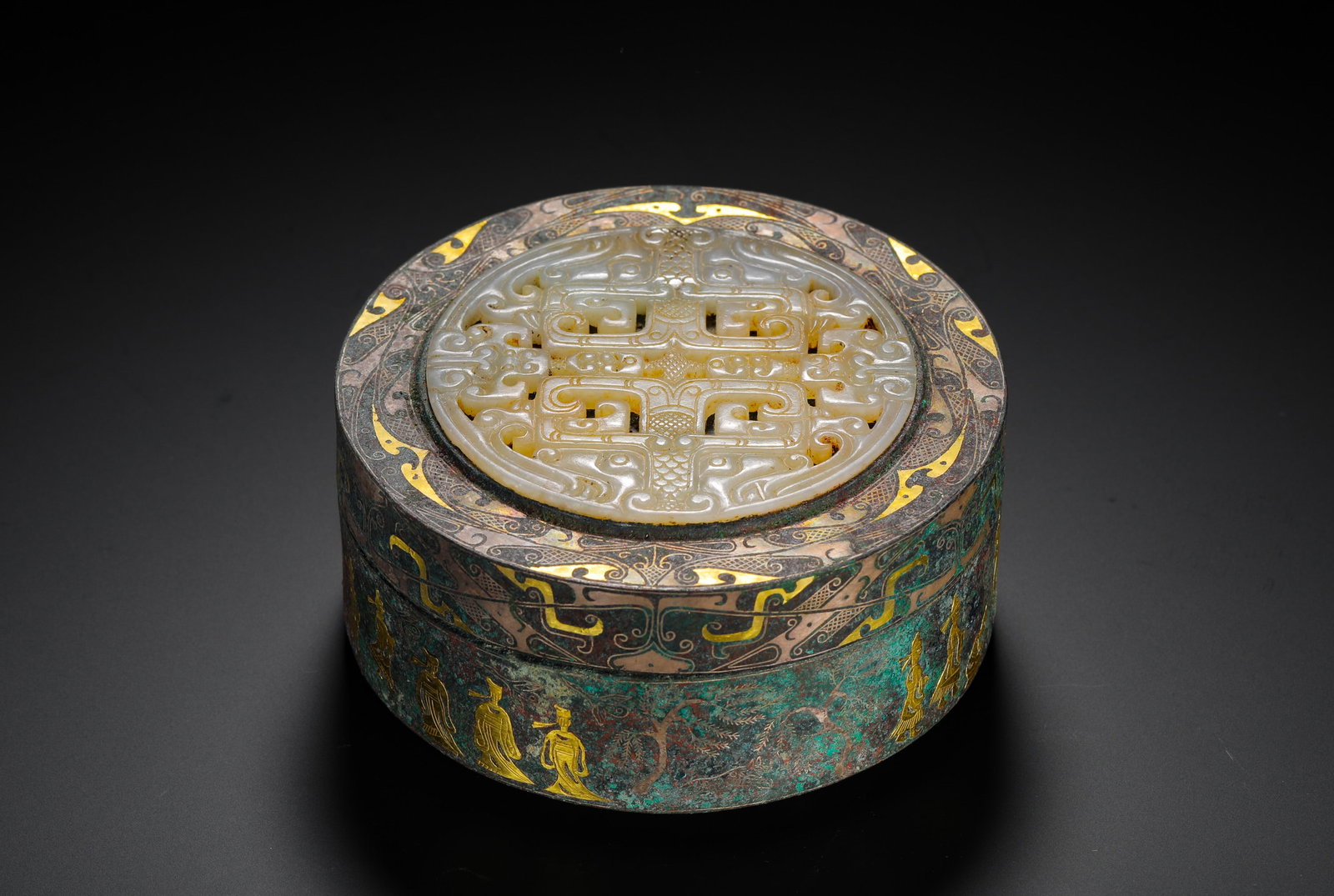 BRONZE INLAID WITH GOLD AND SILVER INLAID JADE BOX FROM THE WARRING STATES PERIOD: H:5cm (1.97in) D:10cm (3.94in) Weight:560g (1.23lb)This is a Warring States Period container, decorated with intricate gold and silver inlaid patterns. The lid is inset with a pierced jade carving. It