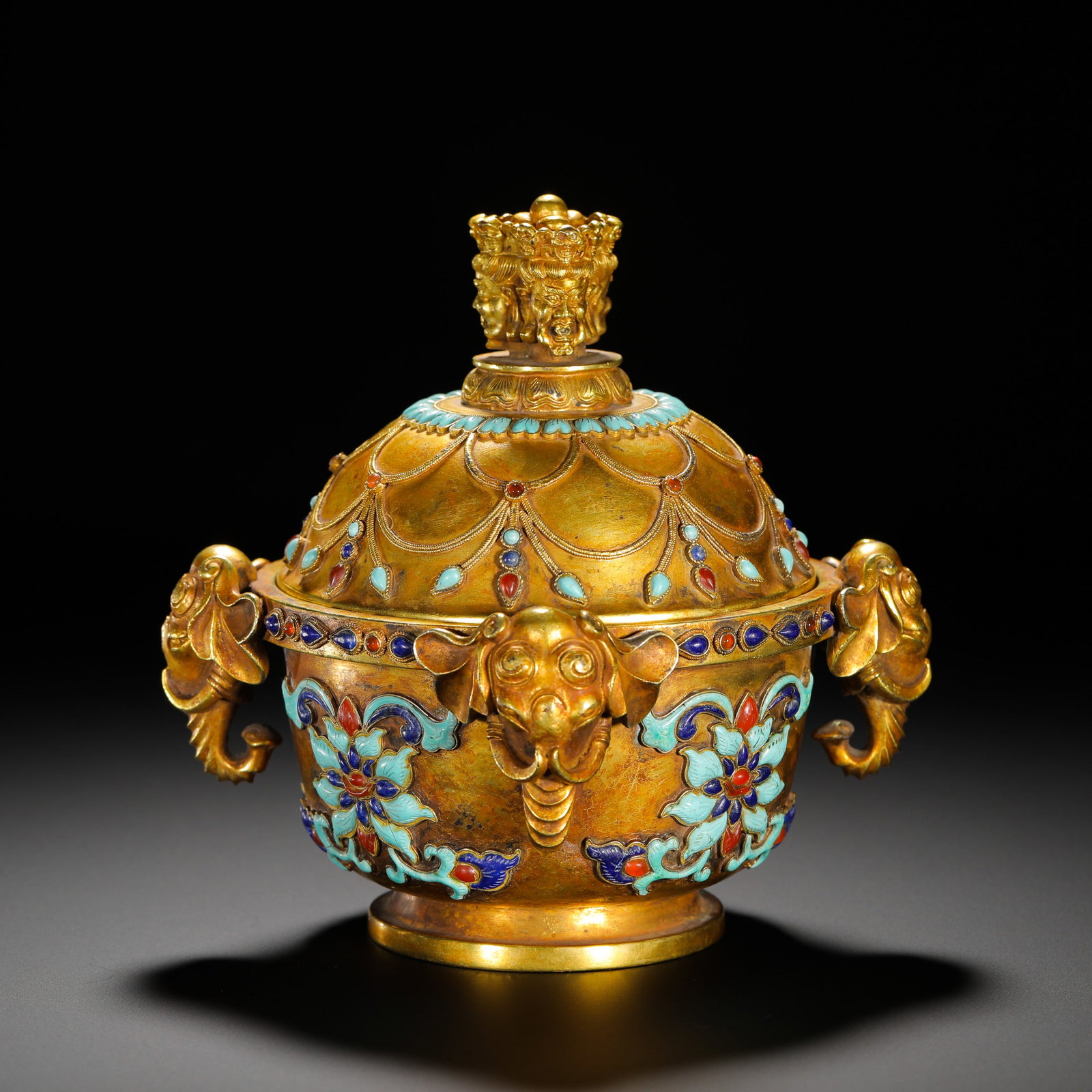 BRONZE GILDED ENAMEL INLAID THREE ELEPHANT EAR COVER BOX: Height:15cm(5.91in) Width:16.5cm(6.50in) Weight:1080g(2.38lb)Gilt bronze covered box with three elephant-shaped handles, Qing Dynasty. It is topped with a multi-beast knob, the body decorated with ena