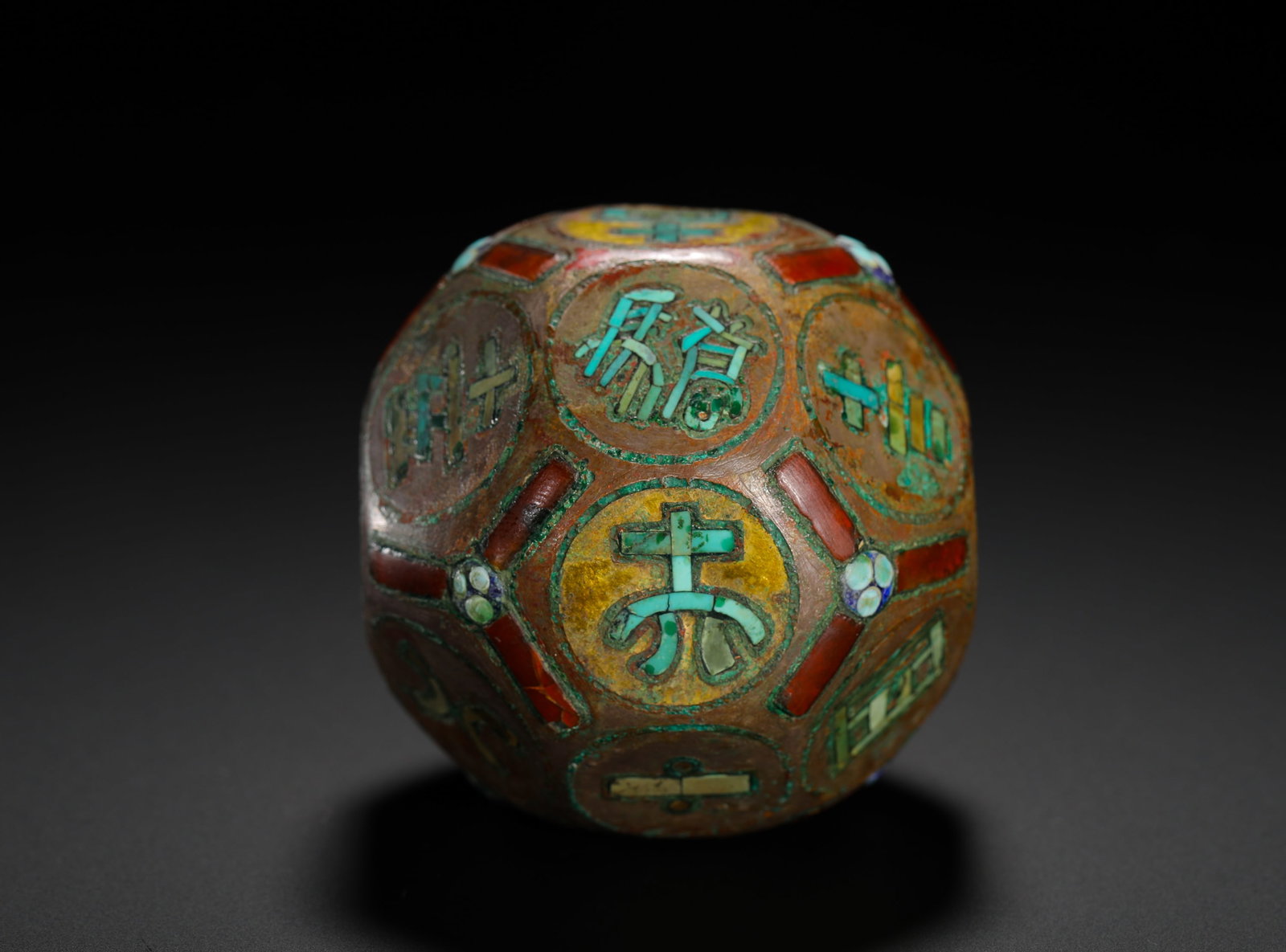 BRONZE CAST DODECAHEDRAL BOONG (DIVINATION DICE): D:5.5cmWeight:258g Dodecahedron bronze gaming divination die. Its surface is inlaid with turquoise, red agate and colored pigments. Each facet features ancient auspicious characters assembled from tur