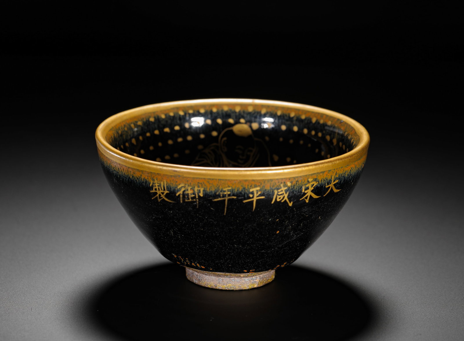 A GOLD-PAINTED BLACK GLAZED JIAN BOWL MADE IN THE XIANPING PERIOD OF THE SONG DYNASTY: Height:7cm(2.76in) D:12cm(4.72in) Weight:310g(0.68lb)Black glazed Jian tea bowl with gold tracing, imperial manufacture of Xianping reign of Great Song Dynasty. Conical tea cup with golden rim, exteri