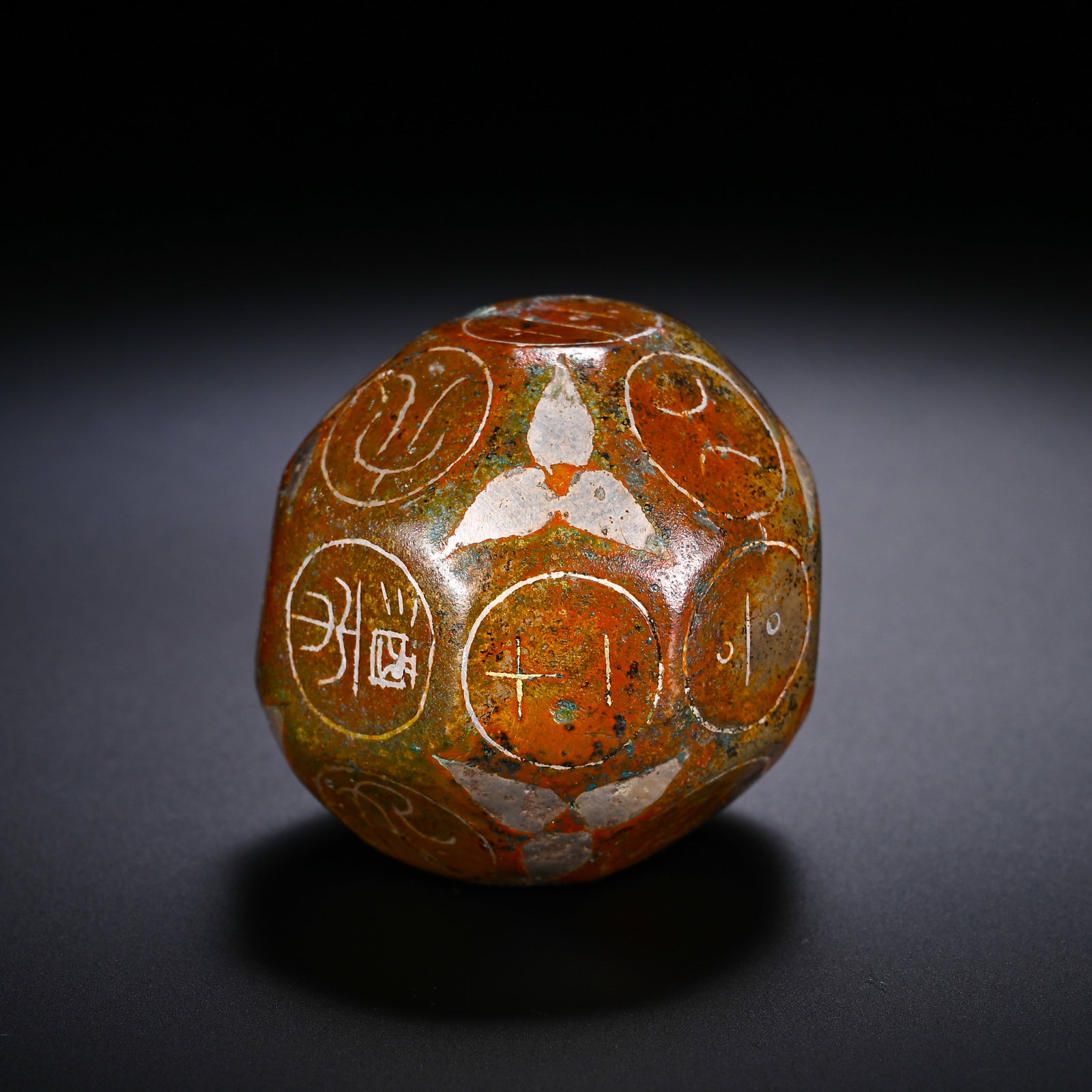HAN DYNASTY BRONZE TWELVE-FACED BORON: D:3.8cmWeight:110gTwelve-sided bronze Boqiong with gold and silver inlay, Han Dynasty. The bronze surface is covered with reddish-brown ancient patina. Each facet is enclosed by a circular frame carve