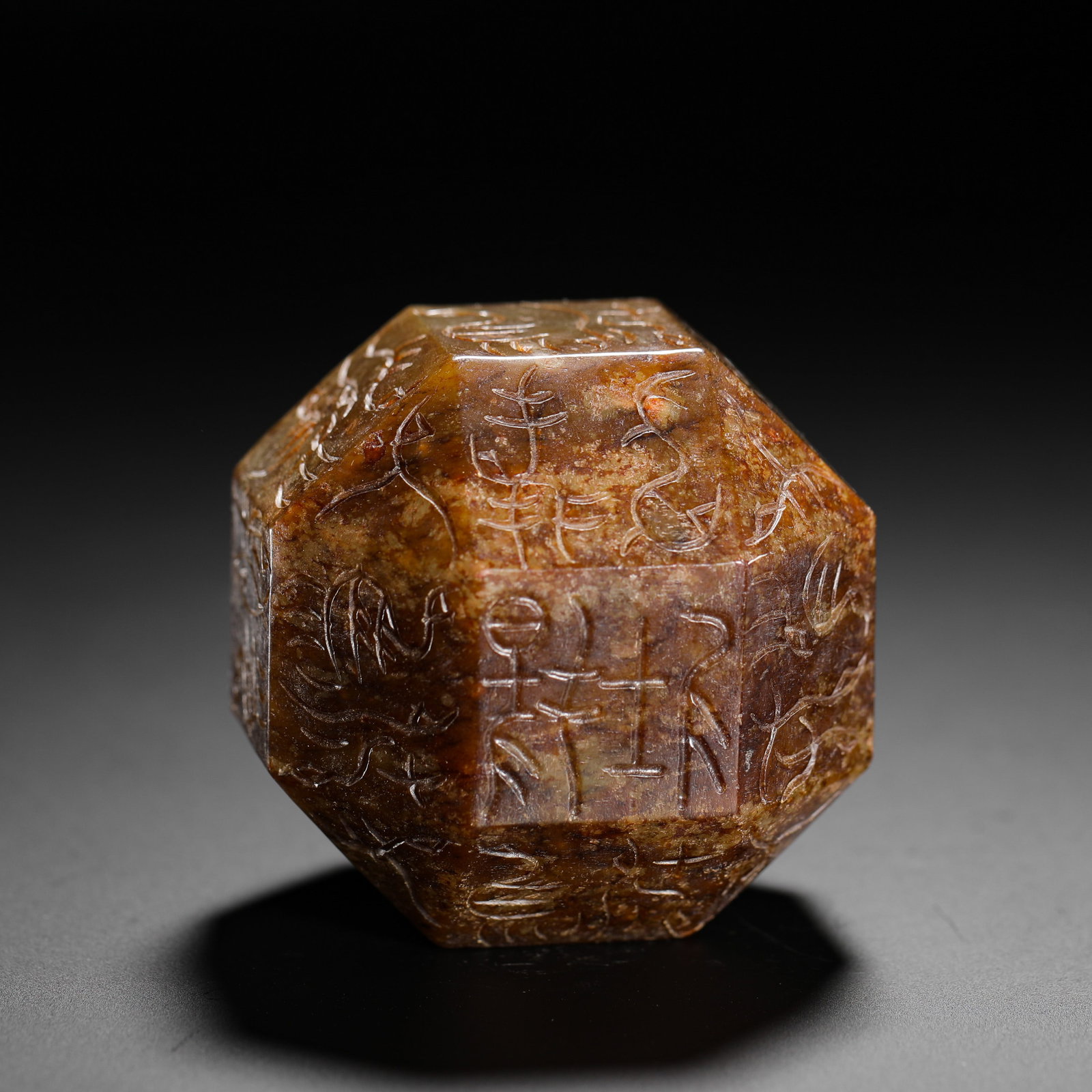 POLYHEDRAL JADE MORTISE OF THE HAN DYNASTY: D:5.6cmWeight:360gA polyhedral jade Gangmao amulet of Han Dynasty covered with yellowish-brown burial patina. Each facet is incised with bird-worm seal exorcism inscriptions, worn threaded through a h