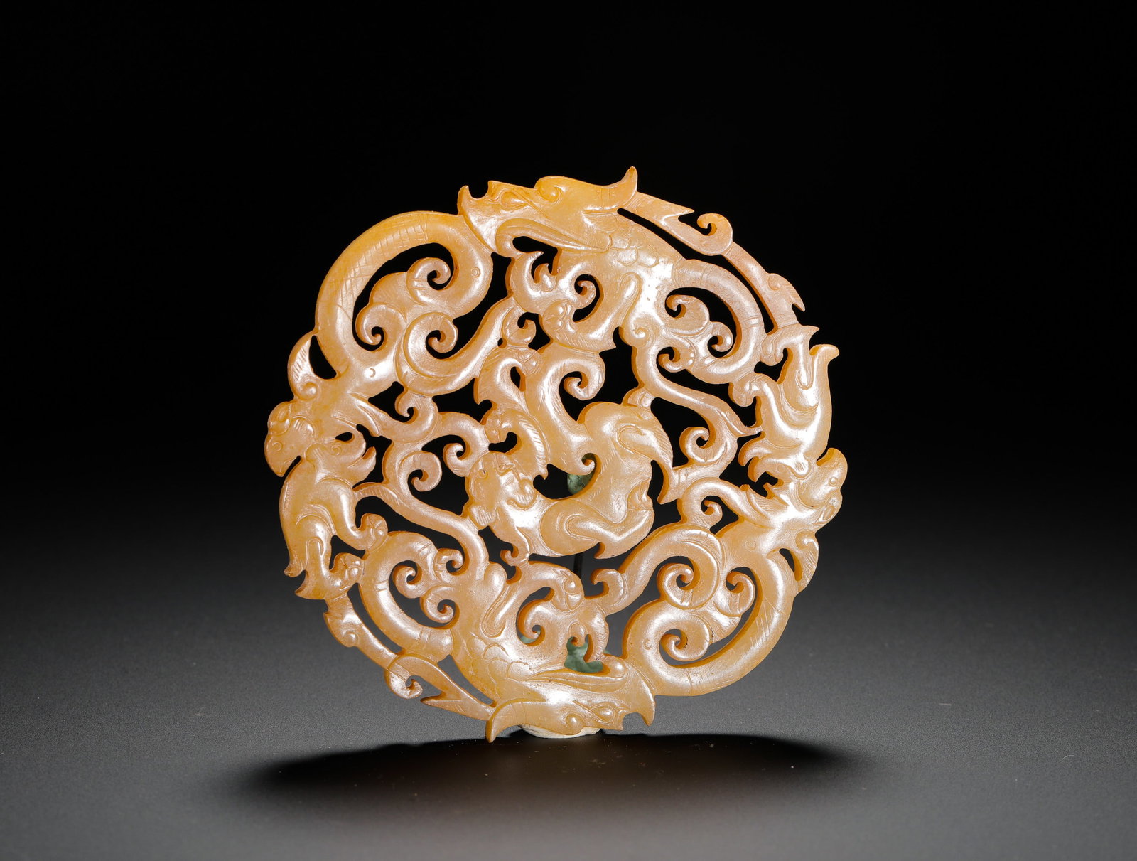 HAN DYNASTY HETIAN JADE ROUND DISC WITH DRAGON PATTERN: D:8.3cm(3.27in) Weight:70g(0.15lb)Han Dynasty yellow jade circular pendant with hollowed intertwined multi-dragon pattern. Solid flat jade openwork carving with uniform warm yellow natural patina, lay