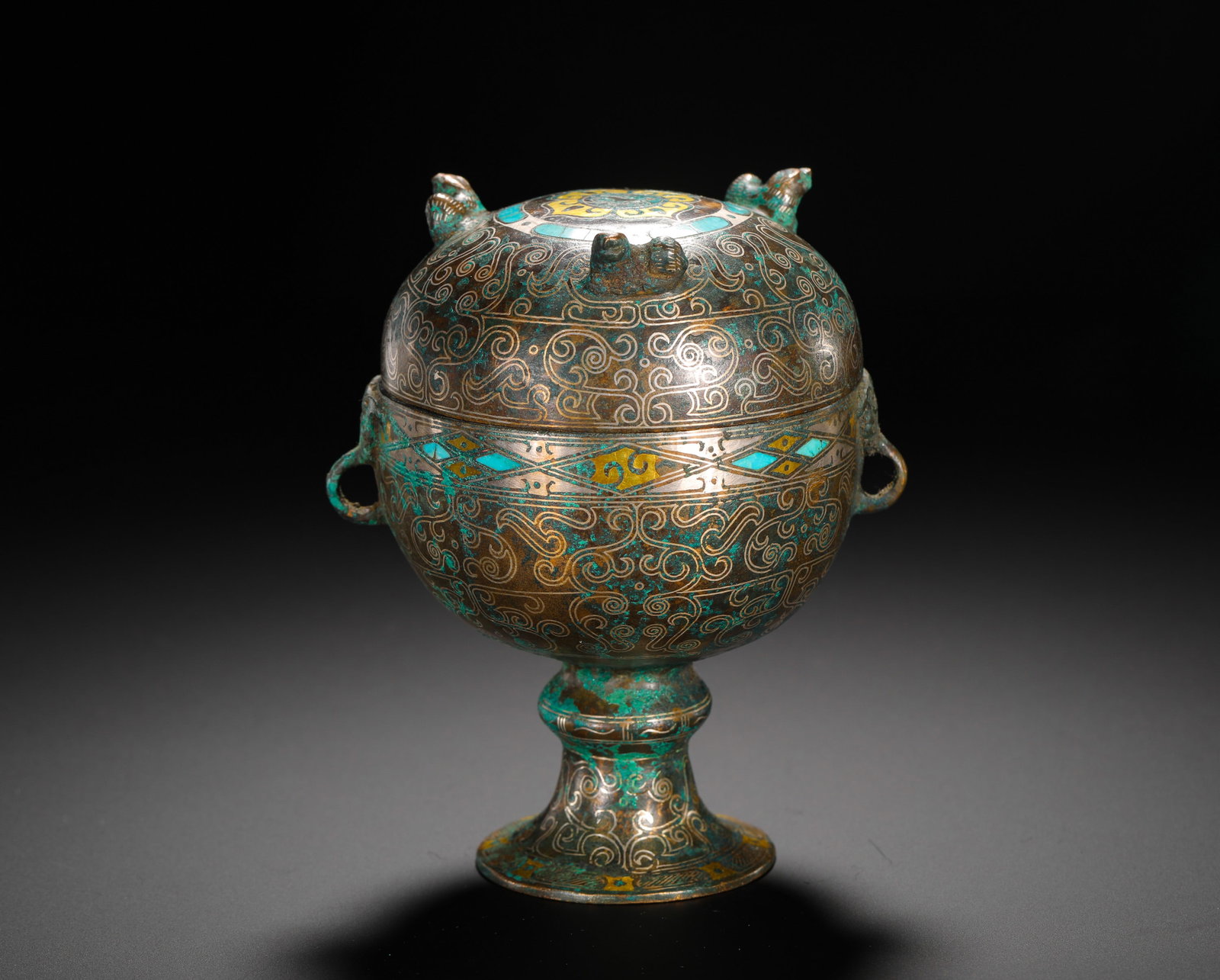 BRONZE INLAID WITH GOLD AND SILVER INLAID WITH TURQUOISE HIGH-FOOTED BEANS FROM THE WARRING STATES: Height:13cm(5.12in) Width:11cm(4.33in) Weight:960g(2.12lb)Warring States bronze stemmed dou vessel inlaid with gold, silver and turquoise, three beasts on lid and intertwined dragon patterns all over,
