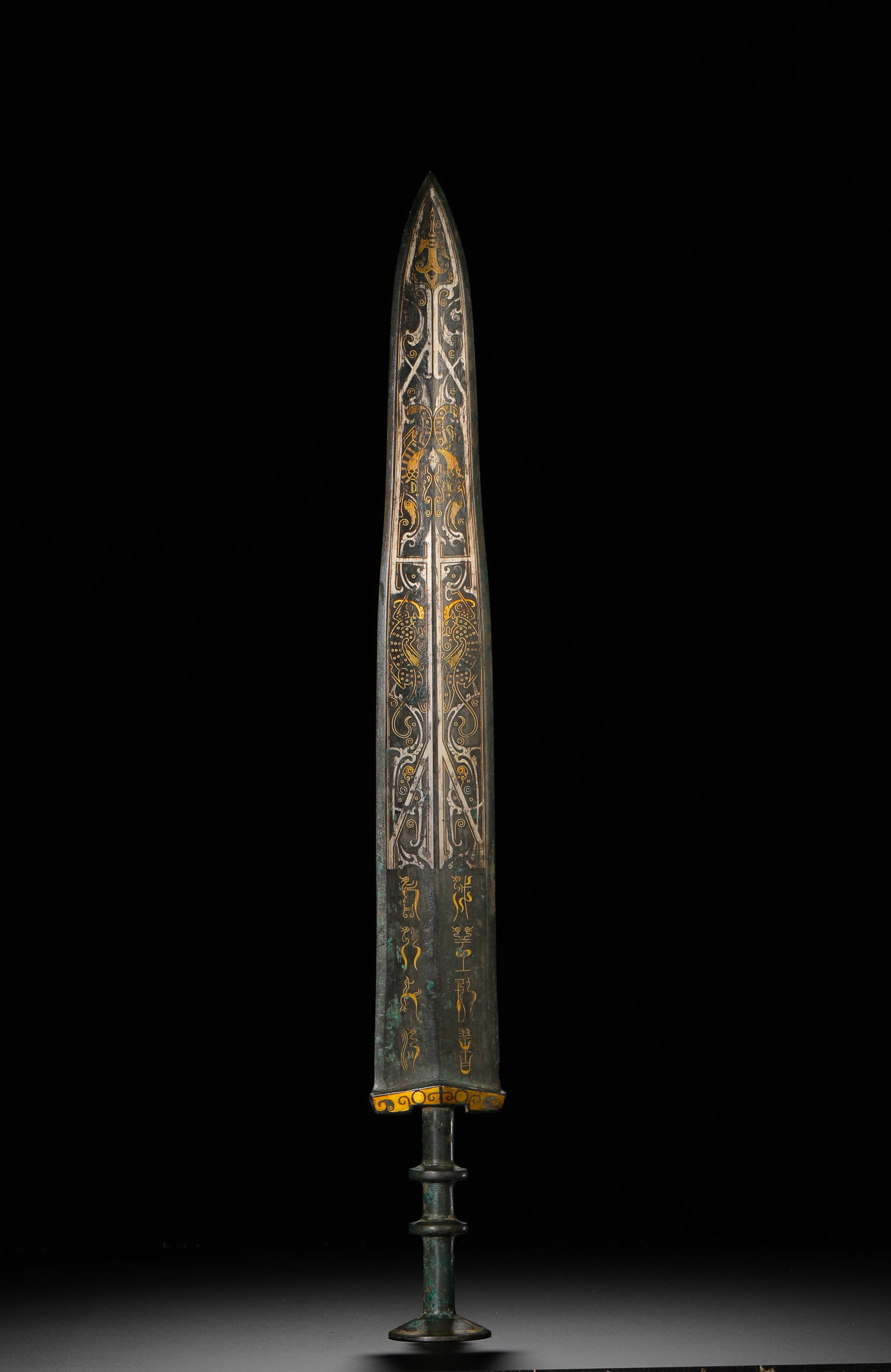 BRONZE SWORD WITH INLAID GOLD AND SILVER INSCRIPTIONS ON BIRDS AND INSECTS FROM THE WARRING STATES: Long:49.5cm(19.49in) Weight:6.2g(0.01lb)Warring States bronze long sword inlaid with gold and silver dragon-phoenix patterns and bird-worm seal script. The blade is divided into two decorative section