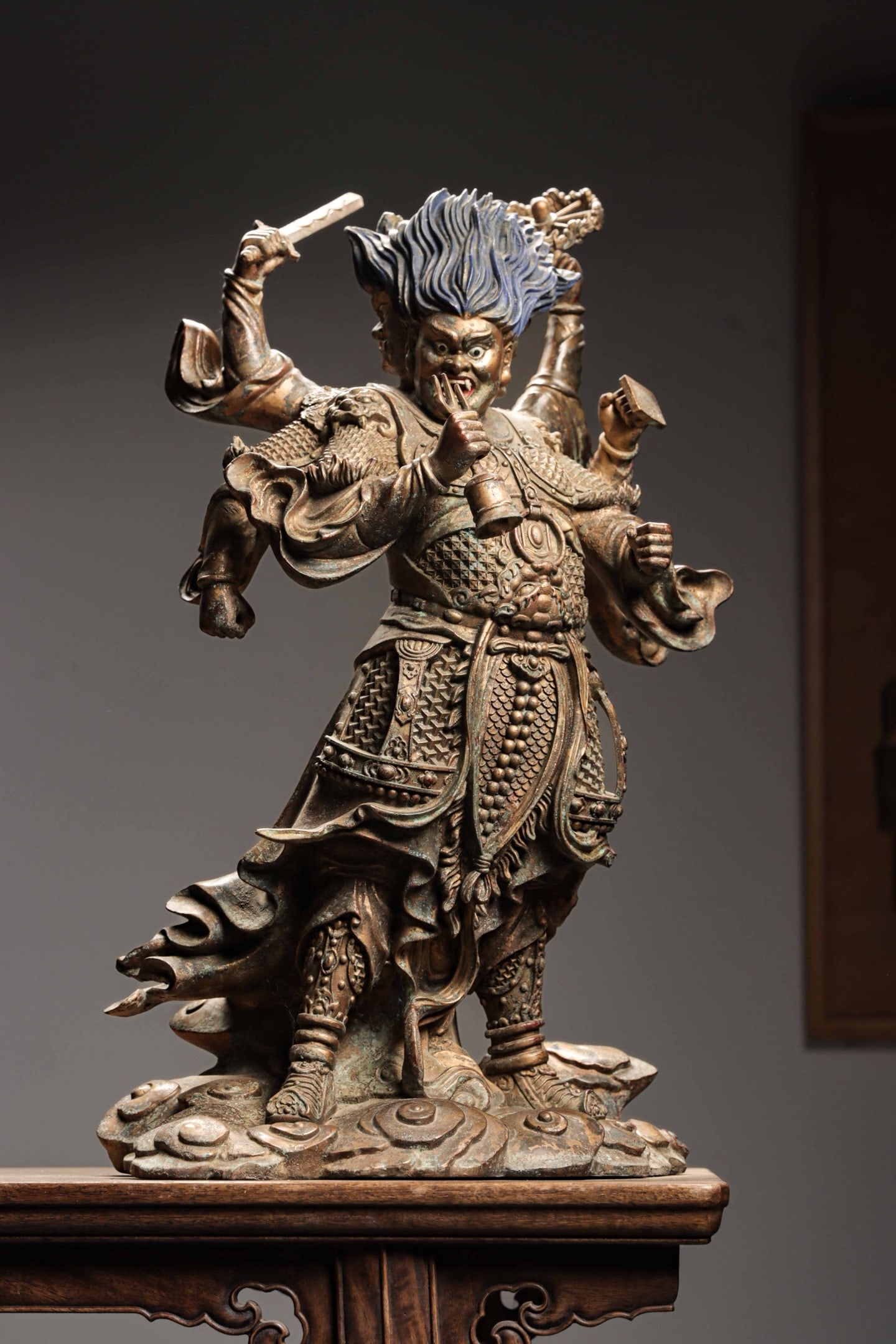 A BRONZE PAINTED STATUE OF THE GUARDIAN KING OF THE MING DYNASTY: Weight:19600g(43.21lb) Height:61cm(24.02in) Width:35cm(13.78in) Thickness:26cm(10.24in) Eight-armed Dharma protector bronze deity statue with mineral color painting, wrathful countenance, holding vari