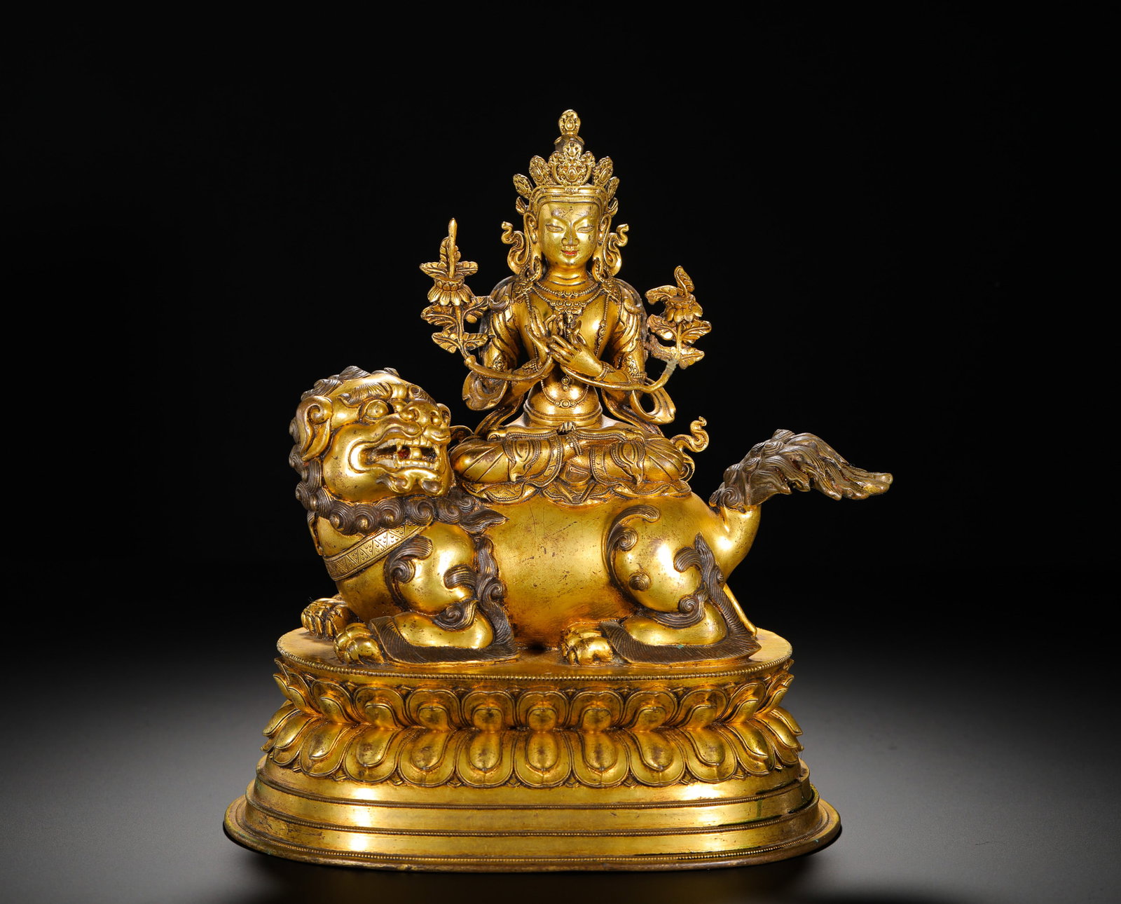 QING DYNASTY GILDED BRONZE STATUE OF MANJUSRI BODHISATTVA RIDING A LION: Height:23.5cm(9.25in) Width:19cm(7.48in) Weight:2720g(6.00lb)Fully gilded copper statue of Manjushri riding lion, Qing Tibetan Buddhism. The Bodhisattva sits in full lotus pose on the back of a snow l