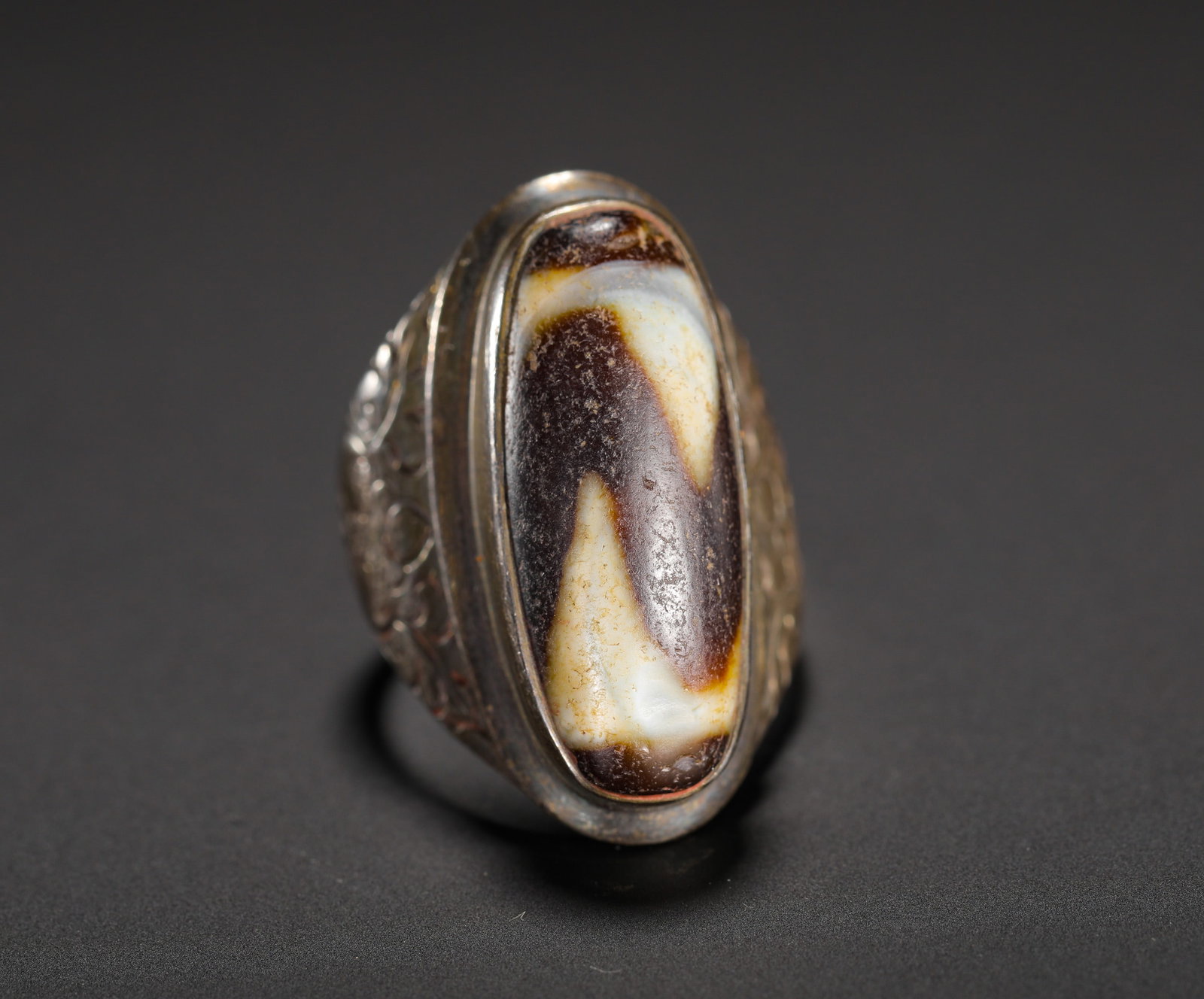 OLD SILVER ENGRAVED FLOWER TIGER-TOOTH SKY BEAD RING: D:3.2cm(1.26in) Weight:15g(0.03lb)Vintage silver ring engraved with floral scrolls set with tiger-tooth dzi bead. The silver band is carved with auspicious winding flower patterns on both sides, holdi