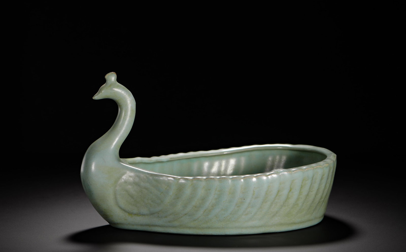 SONG DYNASTY RU KILN SKY BLUE GLAZE PEACOCK-SHAPED WASHED: Height:15cm(5.91in) Width:25cm(9.84in) Weight:890g(1.96lb)Ru kiln sky-celadon peacock-shaped water washer of Northern Song Dynasty, fully sculpted bionic peacock with curved neck and fine crest, oval 