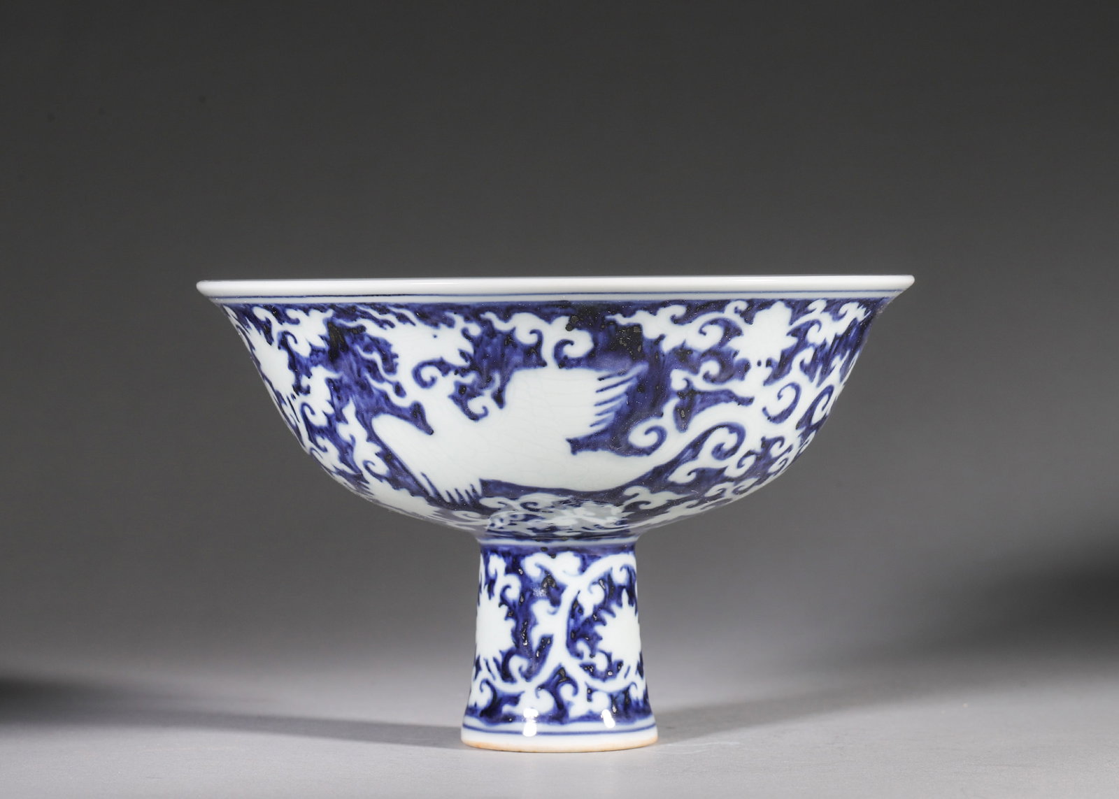 A BLUE AND WHITE RESERVED-DECORATION STEM BOWL WITH INTERLOCKING PHOENIXES, XUANDE PERIOD, MING (1 of 10)