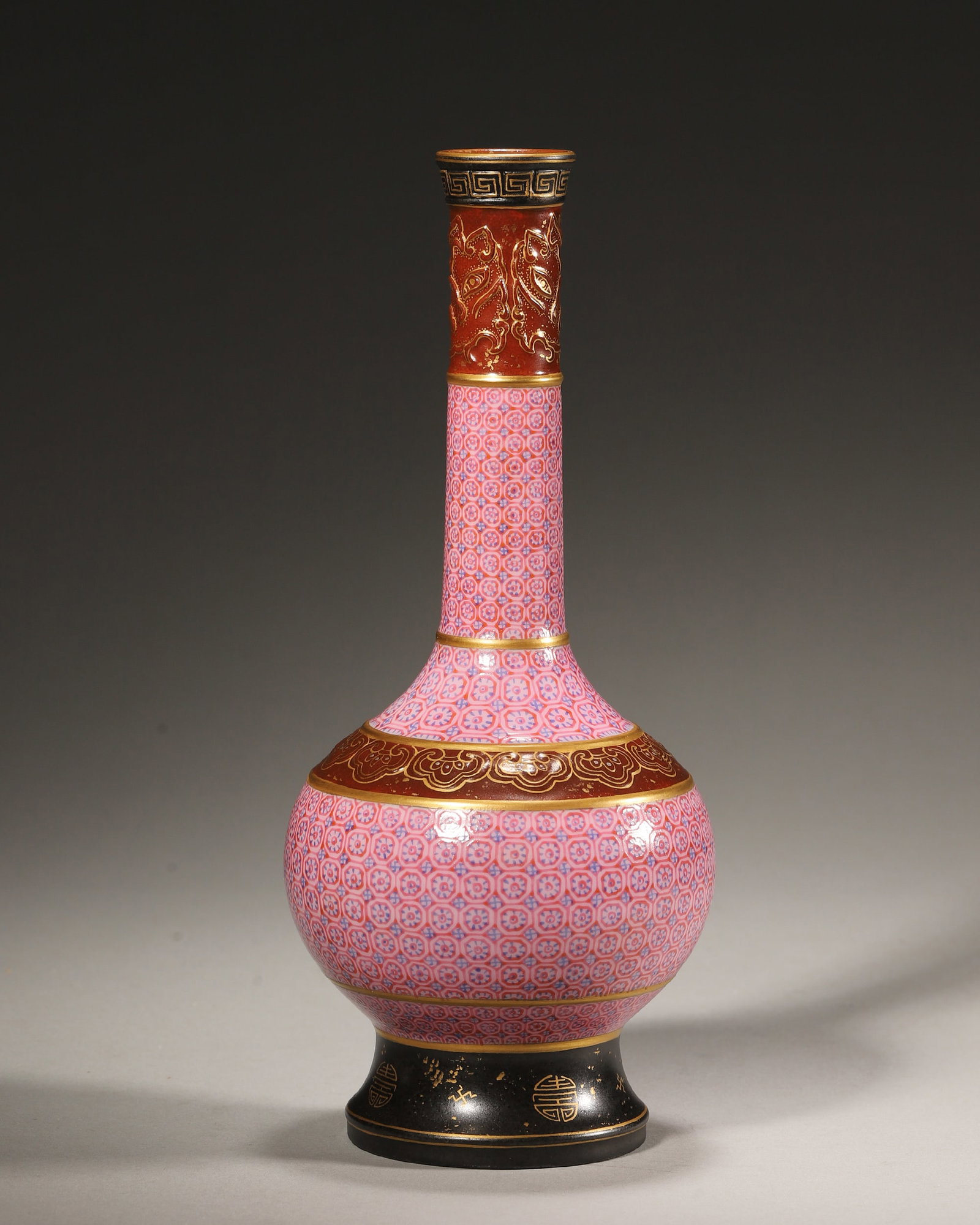 FAMILLE ROSE LONG NECK VASE, QIANLONG PERIOD, QING DYNASTY (1736-1795 AD): D 9cm (3.54 in); H 19cm (7.48 in),Long-neck vase with bulbous body and flared foot. Base covered with brown glaze, bearing embossed six-character Qianlong seal mark. Rim decorated with key-fret patter