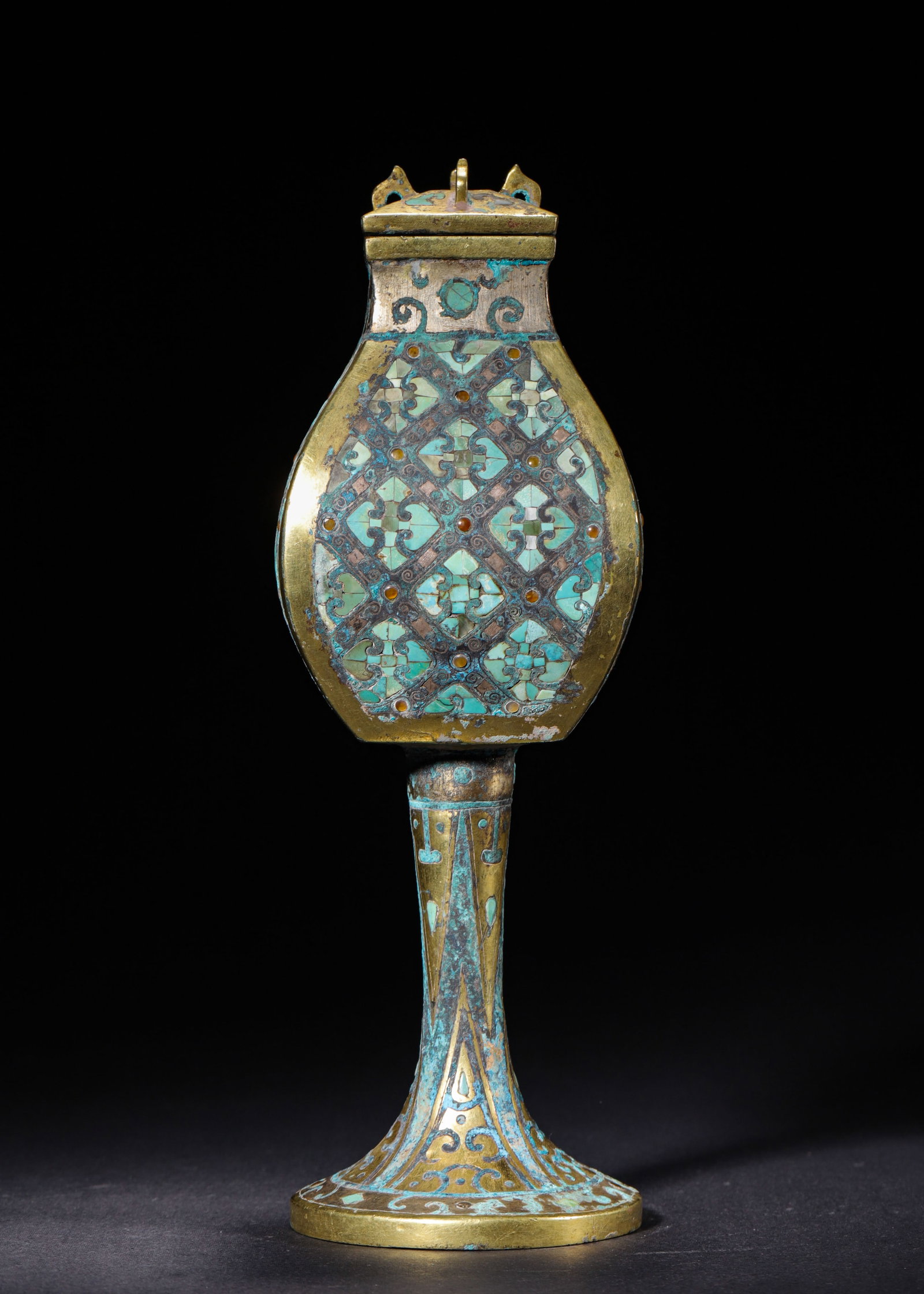 GILT BRONZE TALL SQUARE HU INLAID WITH TURQUOISE AND AGATE, WARRING STATES PERIOD (475-221 BC): H 26cm (10.24 in); W 9cm (3.54 in); Wt 788g (1.74 lb),Bronze vessel gilded overall, fitted with square lid. The flattened square body rises upon a tall stemmed base. Its surface is decorated with rhom
