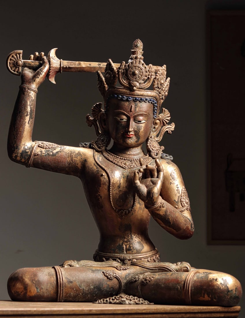 GILT COPPER MANJUSHRI SEATED FIGURE, TIBET, 18TH?C19TH CENTURY AD: Wt 21000g (46.297 lb); H 70cm (27.56 in); W 55cm (21.65 in); D 34cm (13.39 in),Cast gilt copper with partial loss of gilding and original mineral pigments. The bodhisattva wears an ornate crown, seate
