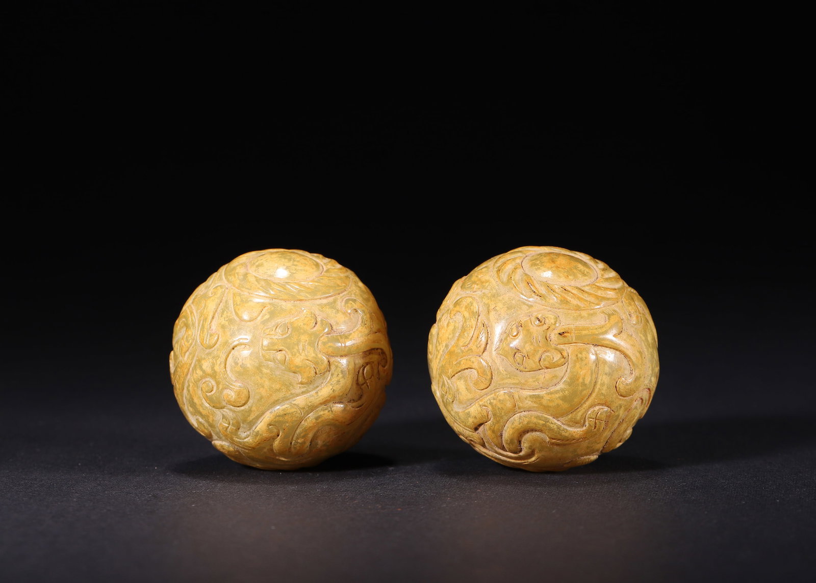 A PAIR OF YELLOW NEPHRITE BEADS WITH HIGH-RELIEF CHILONG DRAGON MOTIFS, HAN DYNASTY: D 3.80cm (1.50 in); Wt 174.00g (0.38 lb),Carved from yellow nephrite suffused with yellow-brown patina, preserved as a complete matching pair. Each bead fully carved with high-relief winding chilong d