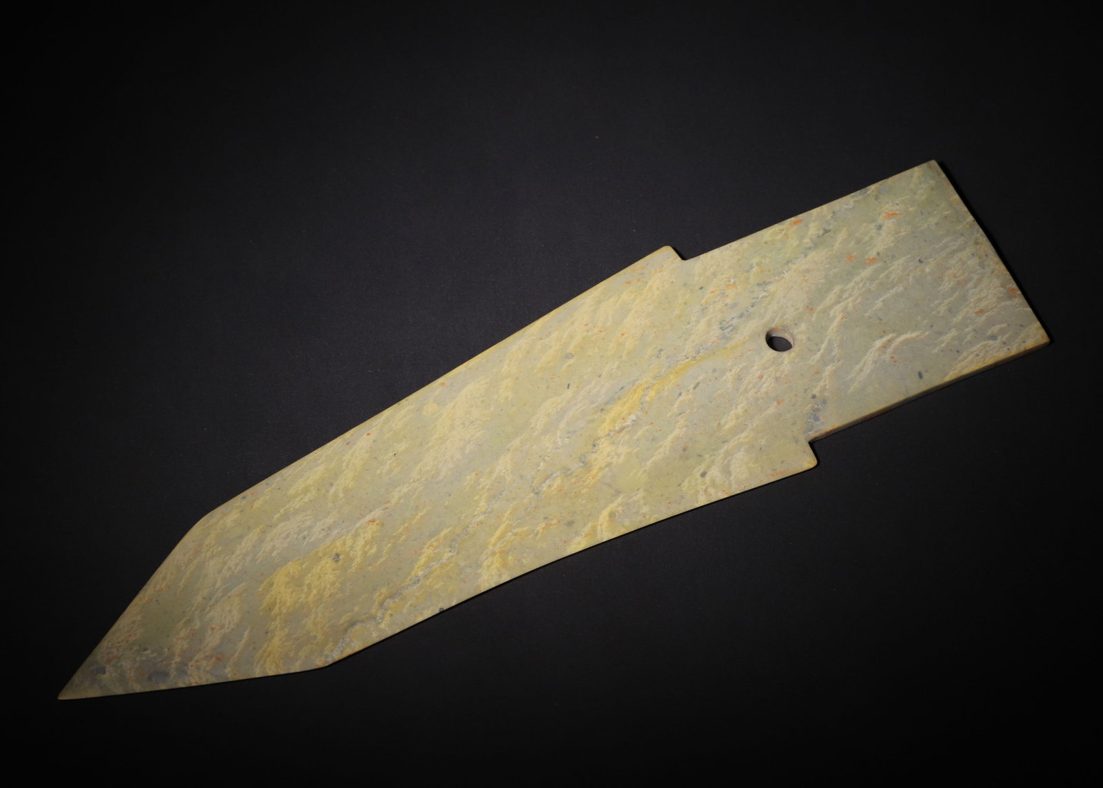 ARCHAIC JADE GE DAGGER-AXE, SHANG DYNASTY (C.1600?C1046 BC): L 37cm (14.57 in); W 10.5cm (4.13 in); Wt 318g (0.70 lb),The jade is wholly permeated by burial patina with yellowish veining and orange earth stains. Elongated form, the blade tapers to a sharp tip w