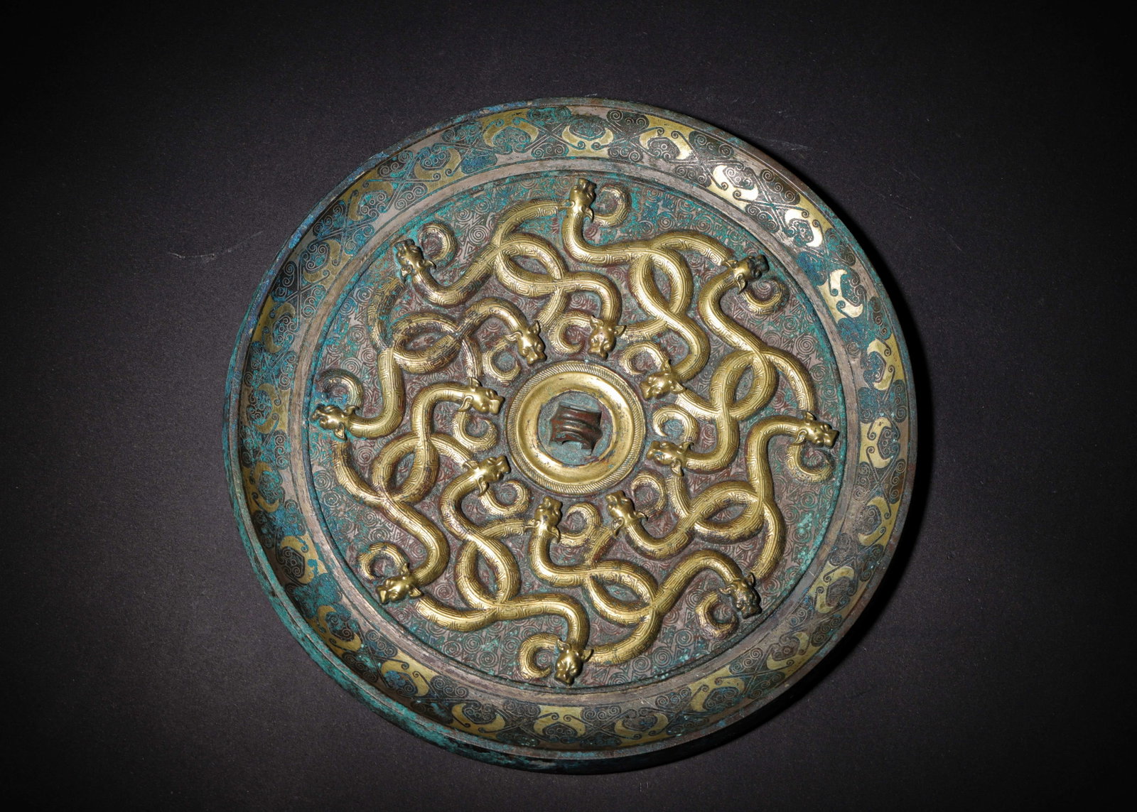 BRONZE MIRROR GILDED WITH INTERTWINED DRAGON MOTIFS, WARRING STATES PERIOD (475-221 BC) (1 of 8)