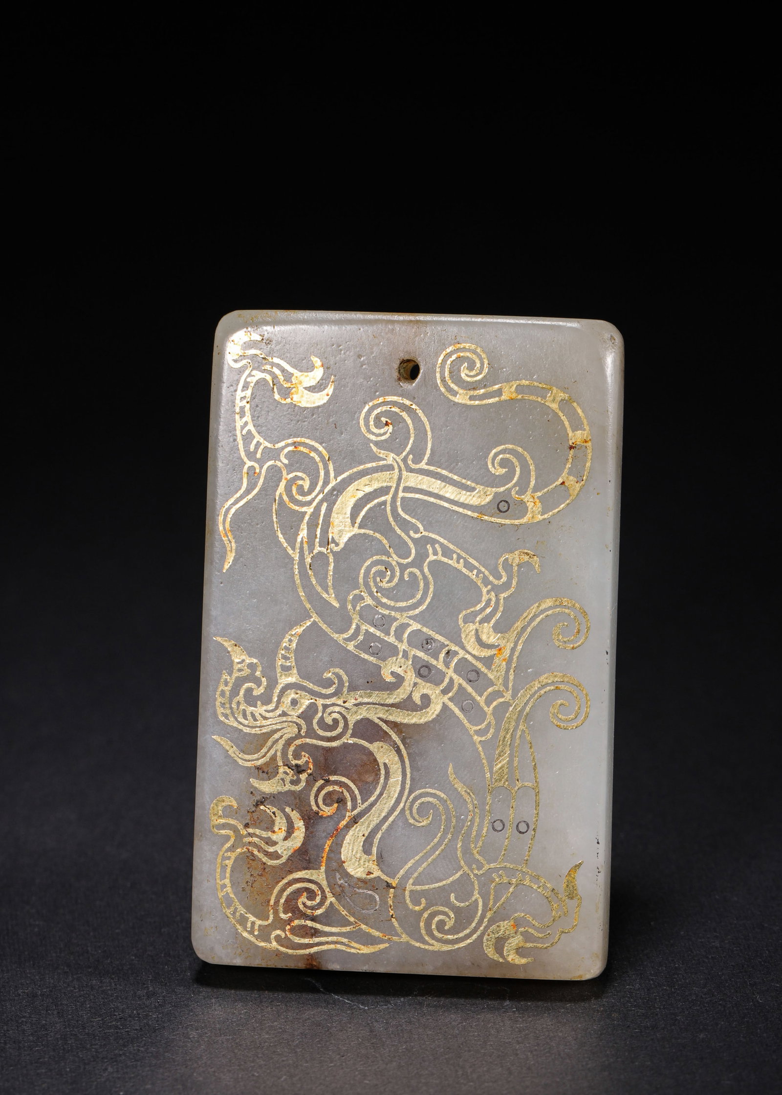 HETIAN JADE PLAQUE WITH INLAID GOLD DRAGON PATTERN, HAN DYNASTY (202 BC ?C 220 AD): L 7cm (2.76 in); W 4.4cm (1.73 in); Wt 73g (0.16 lb),Rectangular pendant plaque carved from Hetian white jade with mild texture and natural aged patina. The obverse features a coiled chi dragon motif 