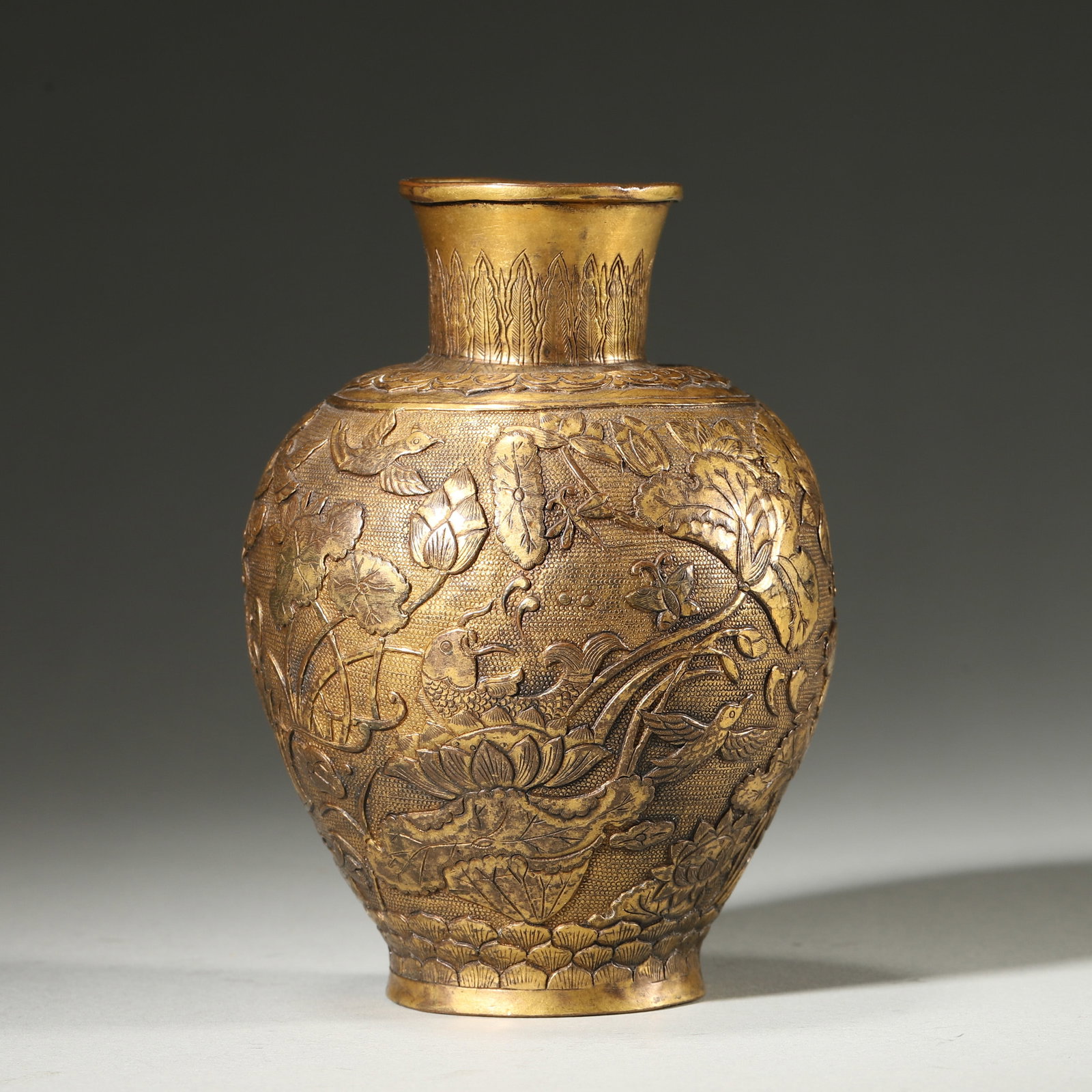 GILT BRONZE VASE WITH LOTUS POND, FISH AND BIRDS MOTIF, MARKED HENGYOU TANG ZHI, QING DYNASTY: Wt 264g (0.58 lb); D 8cm (3.15 in); H 11cm (4.33 in),Gilt bronze vase with flared mouth and rounded body. Richly carved continuous scene of lotus pond, fish, birds and dragonflies on granulated ground