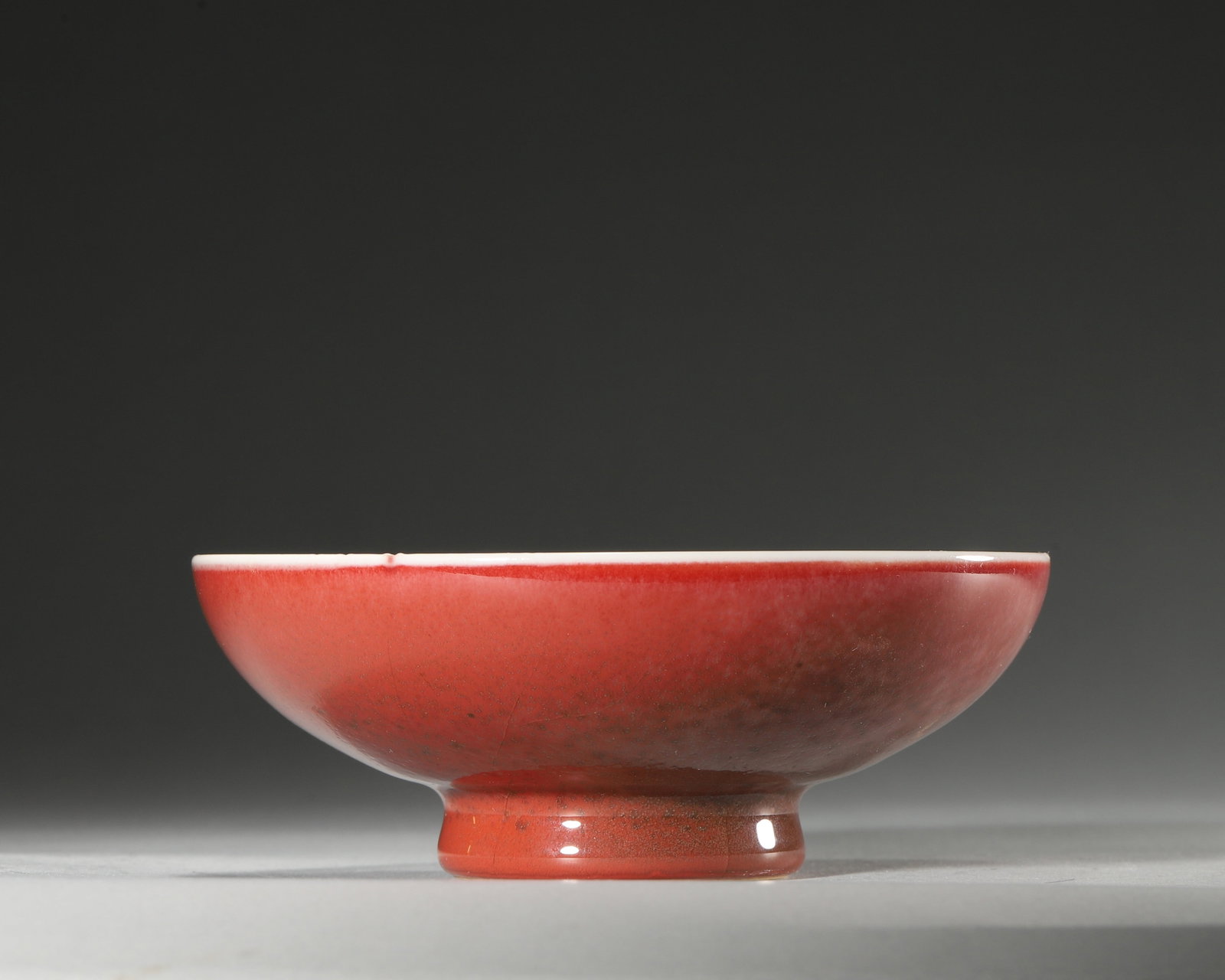 JI-RED GLAZED CHICKEN-HEART BOWL, QING DYNASTY (1644-1912 AD): D 12.5cm (4.92 in); H 4.5cm (1.77 in); Wt 195g (0.43 lb),Modelled in chicken-heart form. Exterior covered with ji-red glaze featuring fine crackles and mottled crimson tone. Interior glazed white with