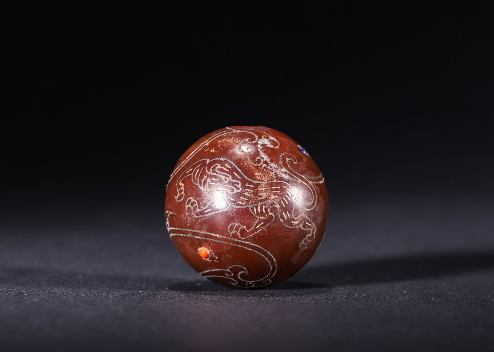 A LARGE RED AGATE BEAD WITH GOLD & SILVER INLAY, INLAID GEMSTONES AND MYTHICAL BEAST MOTIFS, HAN: D 3.60cm (1.42 in); Wt 68.00g (0.15 lb),Round red agate bead with central threading hole. Silver wire inlaid running mythical beasts and cloud scrolls, affixed gold plaques incised with seal script, d