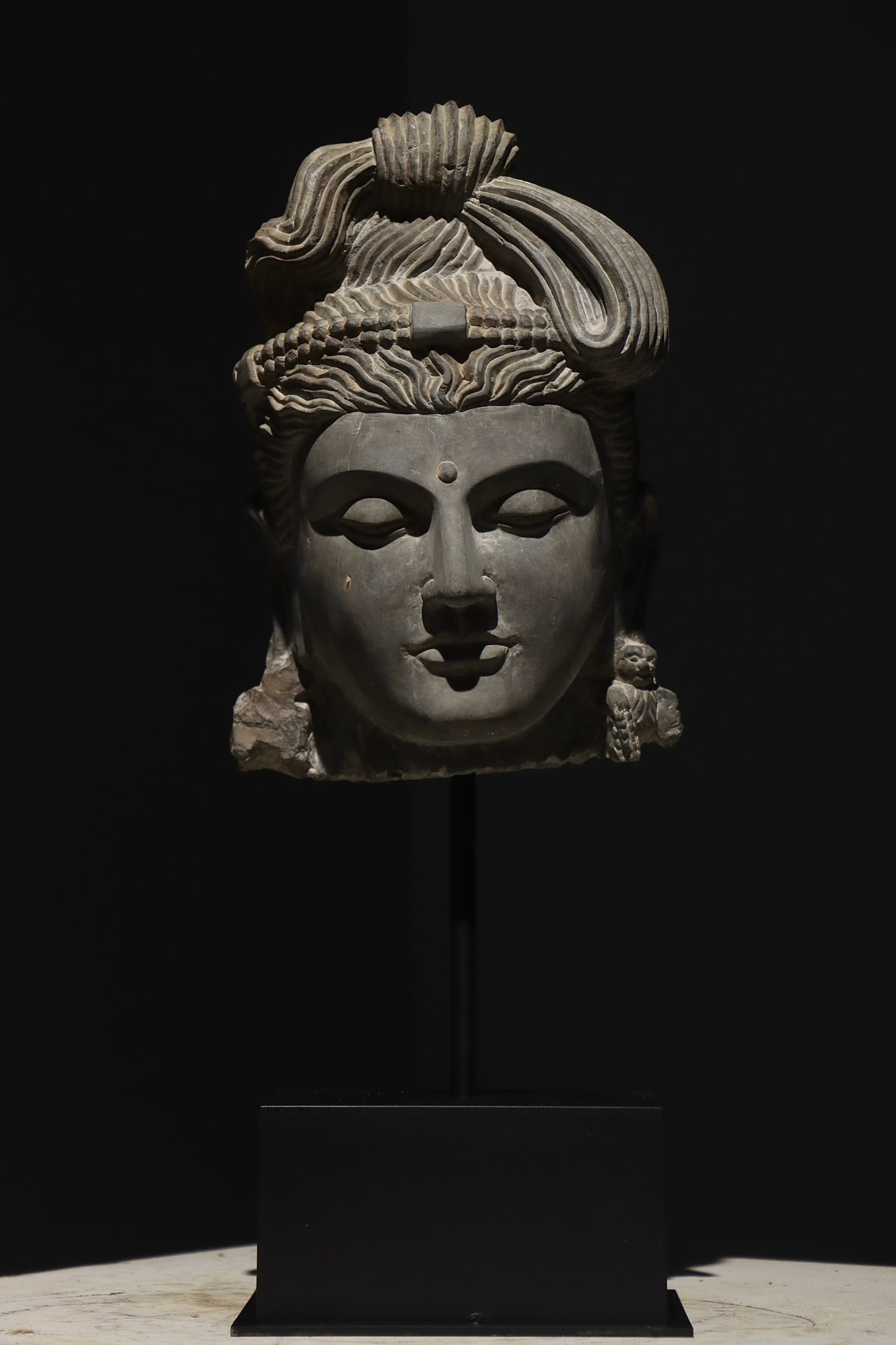 GREY SANDSTONE BODHISATTVA HEAD WITH COILED TOPKNOT & BUDDHA EARRINGS, GANDHARA, 2ND?C3RD CENTURY AD (1 of 7)