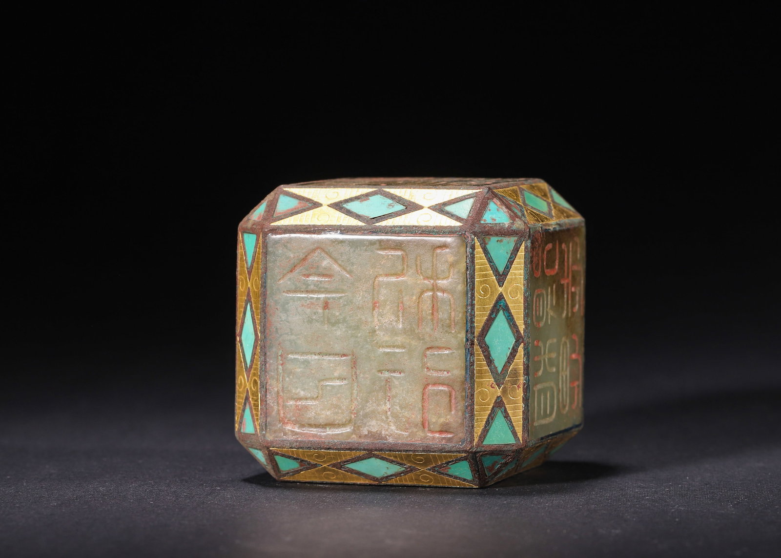 GILT BRONZE & TURQUOISE INLAID CELADON JADE SIX-FACED SEAL, HAN DYNASTY (206 BC?C220 AD): H 6cm (2.36 in); L 6cm (2.36 in); W 6cm (2.36 in); Wt 273g (0.60 lb),Celadon jade six-faced seal of faceted square form, framed with gilt bronze inlaid with turquoise geometric motifs. All sides incis