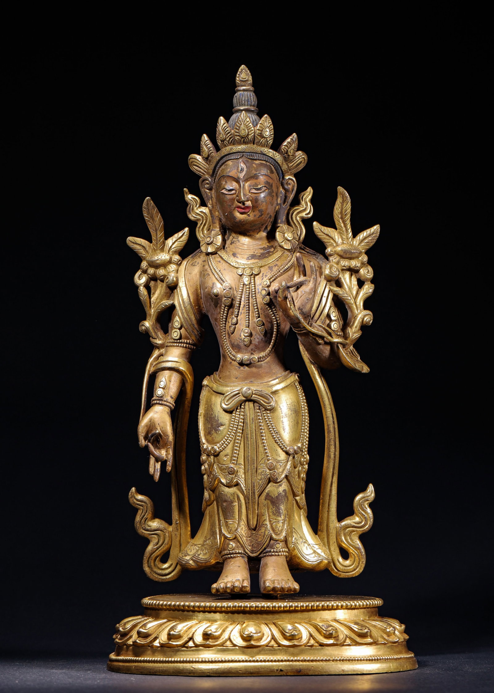 GILT BRONZE STANDING WHITE TARA, QING DYNASTY (1644-1912 AD): L 17cm (6.69 in); W 13cm (5.12 in); H 34cm (13.39 in); Wt 3591g (7.92 lb),Cast copper with gilding. White Tara stands upright, adorned with five-leaf crown and third eye on forehead, possessing serene