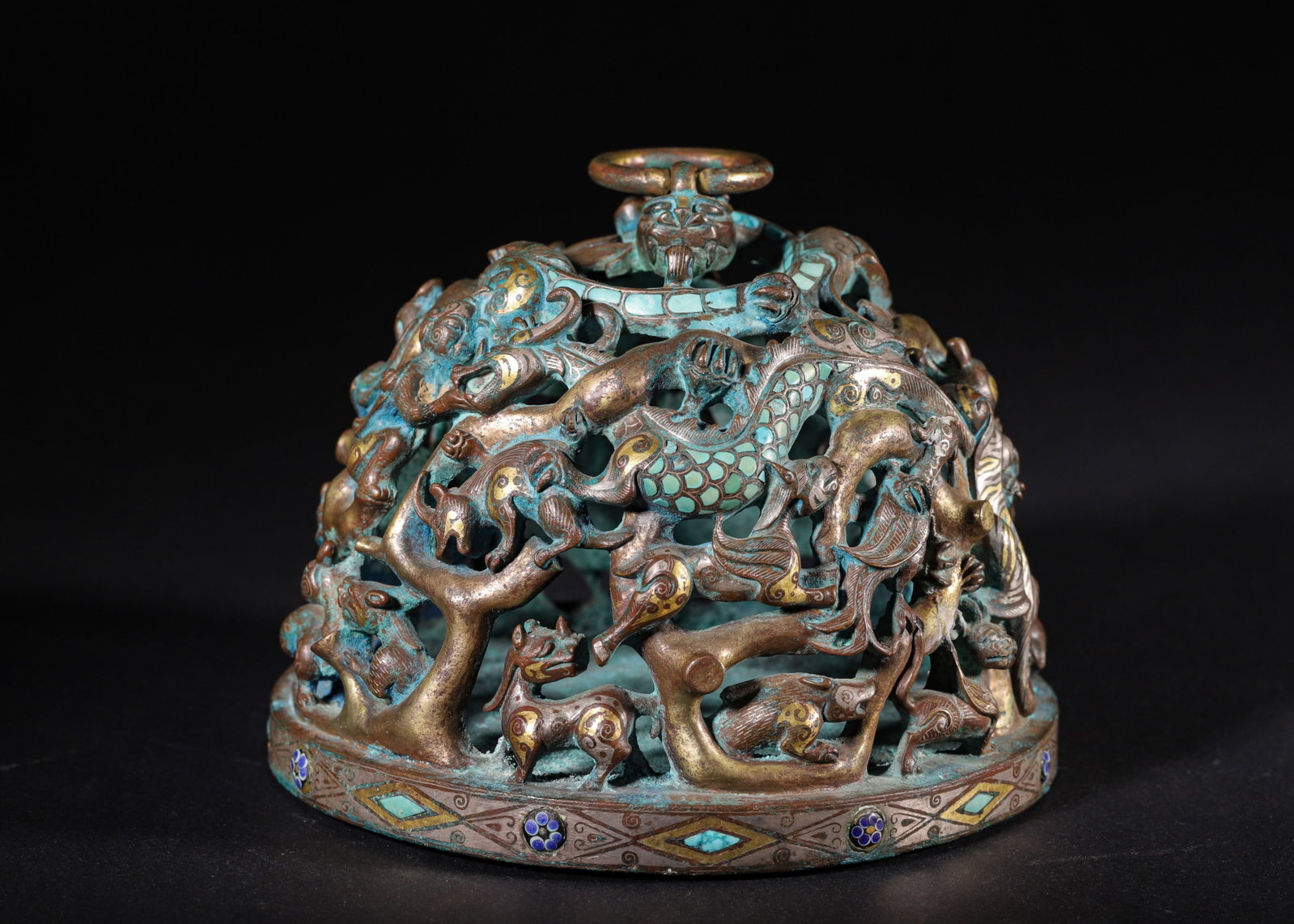OPENWORK BRONZE MAT WEIGHT WITH GOLD AND SILVER INLAY, TURQUOISE AND INTERTWINED BEASTS (HAN: H 13cm (5.12 in); D 17cm (6.69 in); Wt 3503g (7.72 lb),Domed bronze mat weight topped with a ring-holding chilong. Openwork high relief depicts intertwined mythical beasts. Decorated with gold and sil