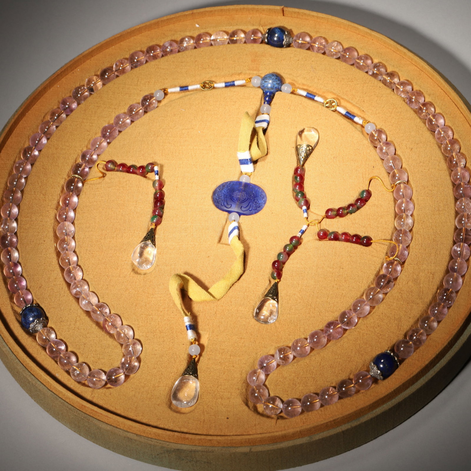 AMETHYST COURT NECKLACE (CHAO ZHU), QING DYNASTY (1636-1912): Wt 511g (1.13 lb); D 1.3cm (0.51 in),Complete set of court necklace composed of one hundred and eight amethyst beads with soft violet hue, interspersed with four lapis lazuli Buddha heads. Fitted with