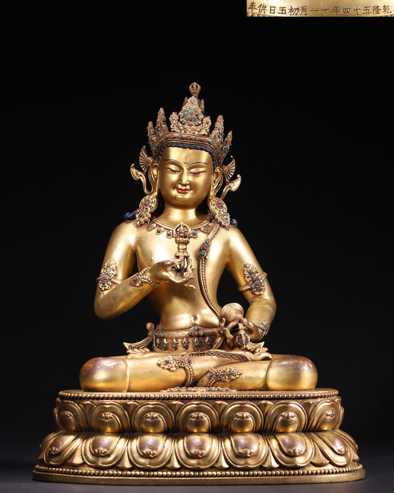 IMPERIAL GILT BRONZE INLAID VAJRADHARA SEATED FIGURE, DATED 54TH YEAR OF QIANLONG REIGN, QING: L 24.00cm (9.45 in); W 16.00cm (6.30 in); H 31.00cm (12.20 in); Wt 4000.00g (8.82 lb),Imperial palace workshop casting, copper body fully gilded. Five-leaf crown, necklaces and armlets inlaid with red