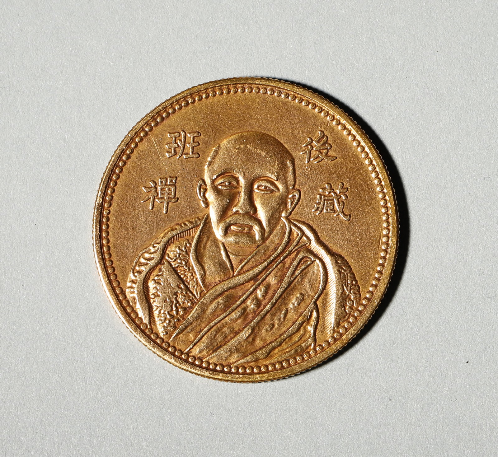 QIANLONG PERIOD (1736-1795) GOLD COIN DEPICTING PANCHEN LAMA, QING DYNASTY: Wt 19g (0.042 lb); D 3.3cm (1.299 in),Gold coin. Obverse features portrait of Panchen Lama with Chinese inscriptions. Reverse bears Dharma Wheel motif, marked Qianlong and Tibetan characters. Fine eng