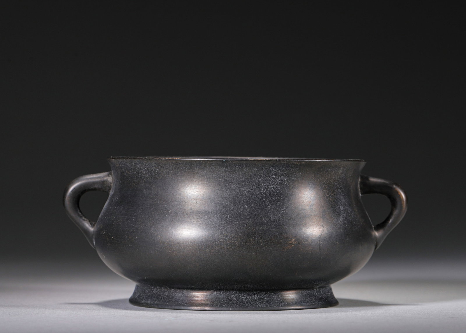 MING DYNASTY BRONZE CENSER WITH SCROLL HANDLES, MARK "DA MING XUANDE NIAN ZHI??: W 14cm (5.51 in); H 6cm (2.36 in); Wt 489g (1.078 lb),Cast from single piece of fine bronze, the censer features a plump rounded body with flared rim, paired gentle scroll handles and a circular foot.