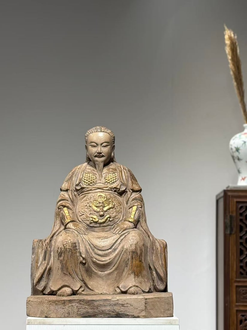 GILT PAINTED WOOD SEATED STATUE OF ZHENWU EMPEROR, MING DYNASTY, 1368?C1644 AD: H 56cm (22.047 in); W 40cm (15.75 in),Carved from single wood block with surviving original gilding. Zhenwu Emperor with loose long hair, serene facial features and a flowing beard. Armoured under a T