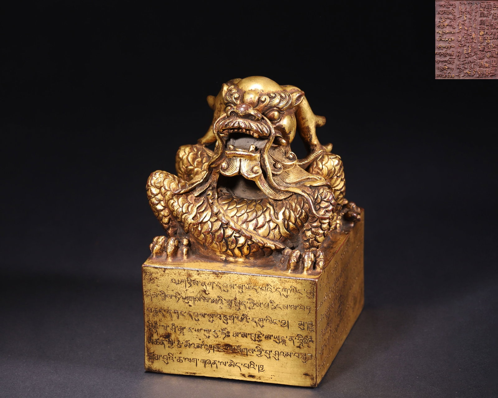 GILT BRONZE IMPERIAL SEAL WITH COILED DRAGON KNOB, SINO-TIBETAN INSCRIPTIONS, QING DYNASTY: L 11.50cm (4.53 in); W 9.50cm (3.74 in); H 14.00cm (5.51 in); Wt 1876.00g (4.14 lb),Cast copper fully gilded, square seal base surmounted by a deeply carved coiled dragon knob with meticulously detail