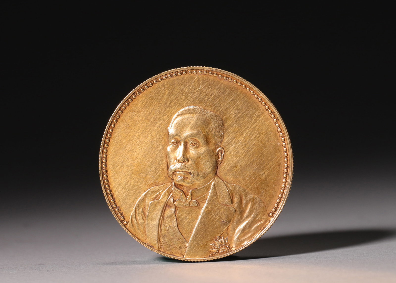 GOLD COIN WITH PORTRAIT OF GUANGXU EMPEROR, YIYOU YEAR, GUANGXU PERIOD (1875-1908), QING DYNASTY: Wt 19g (0.042 lb); D 3.3cm (1.299 in),Gold coin. Obverse bears formal portrait of Guangxu Emperor with corresponding Chinese inscriptions. Reverse decorated with dragon surrounded by longevity charact