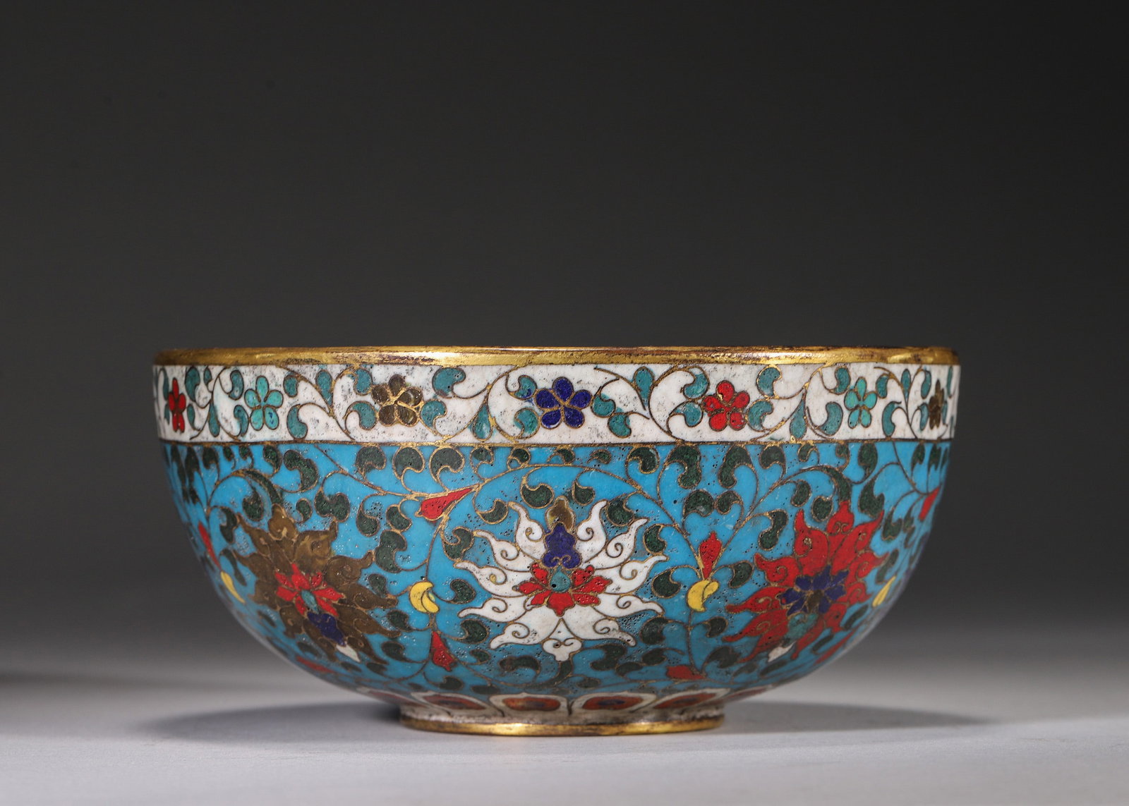 GILT COPPER-BODY CLOISONNE BOWL WITH SEA BEASTS AND INTERLOCKING LOTUS SCROLLS, JINGTAI MARK: H 7.00cm (2.76 in); D 15.00cm (5.91 in); Wt 681.00g (1.50 lb),Gilt copper cloisonne appreciation bowl with gilded rim and foot. The exterior is covered with interlocking lotus blossoms on turquoise gr