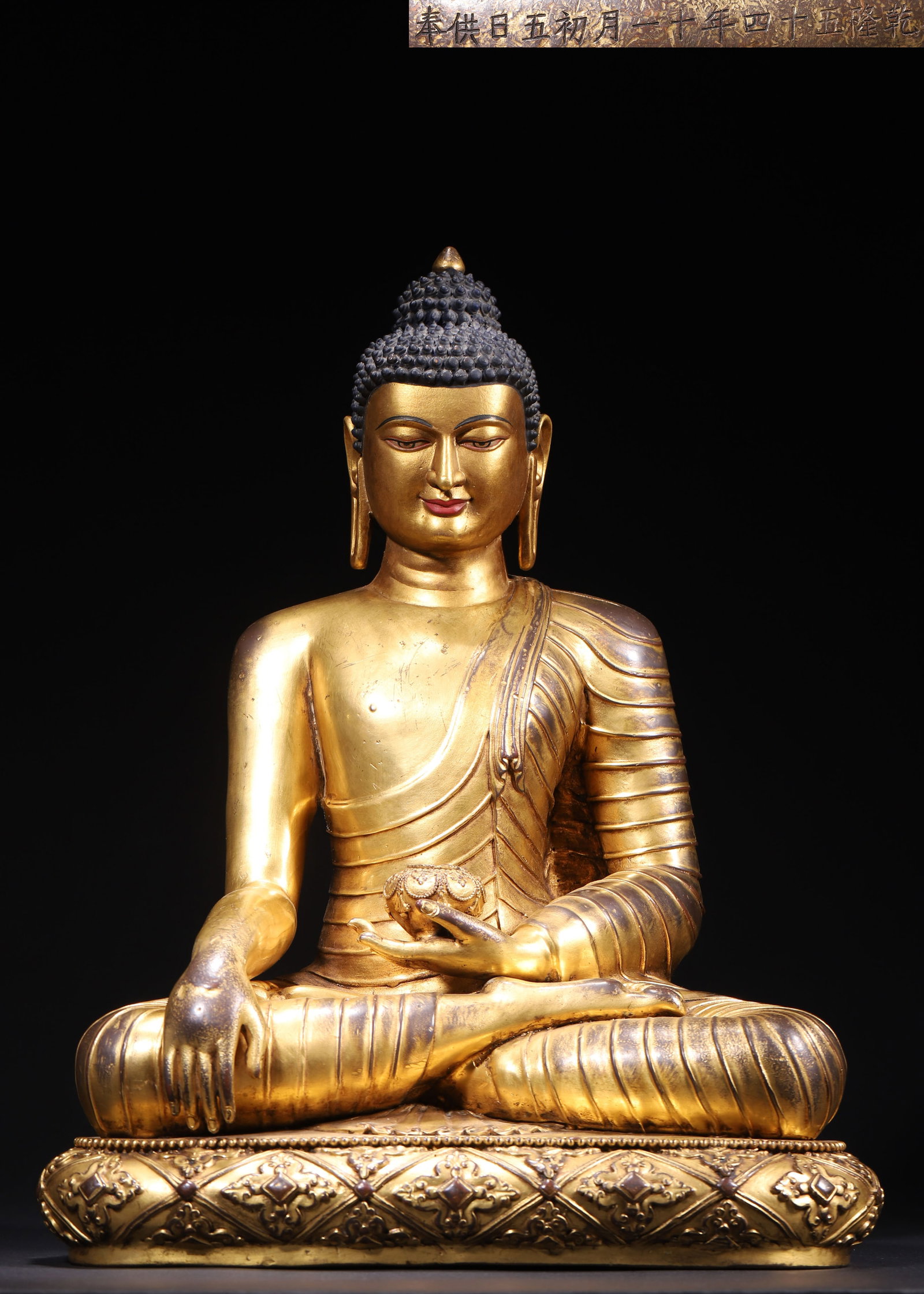 IMPERIAL GILT BRONZE SHAKYAMUNI BUDDHA SEATED FIGURE, DATED 54TH YEAR OF QIANLONG REIGN, QING: L 30.00cm (11.81 in); W 21.00cm (8.27 in); H 38.00cm (14.96 in); Wt 7295.00g (16.08 lb),Imperial palace workshop casting, full gilded copper body with dark blue snail hair, calm and compassionate faci