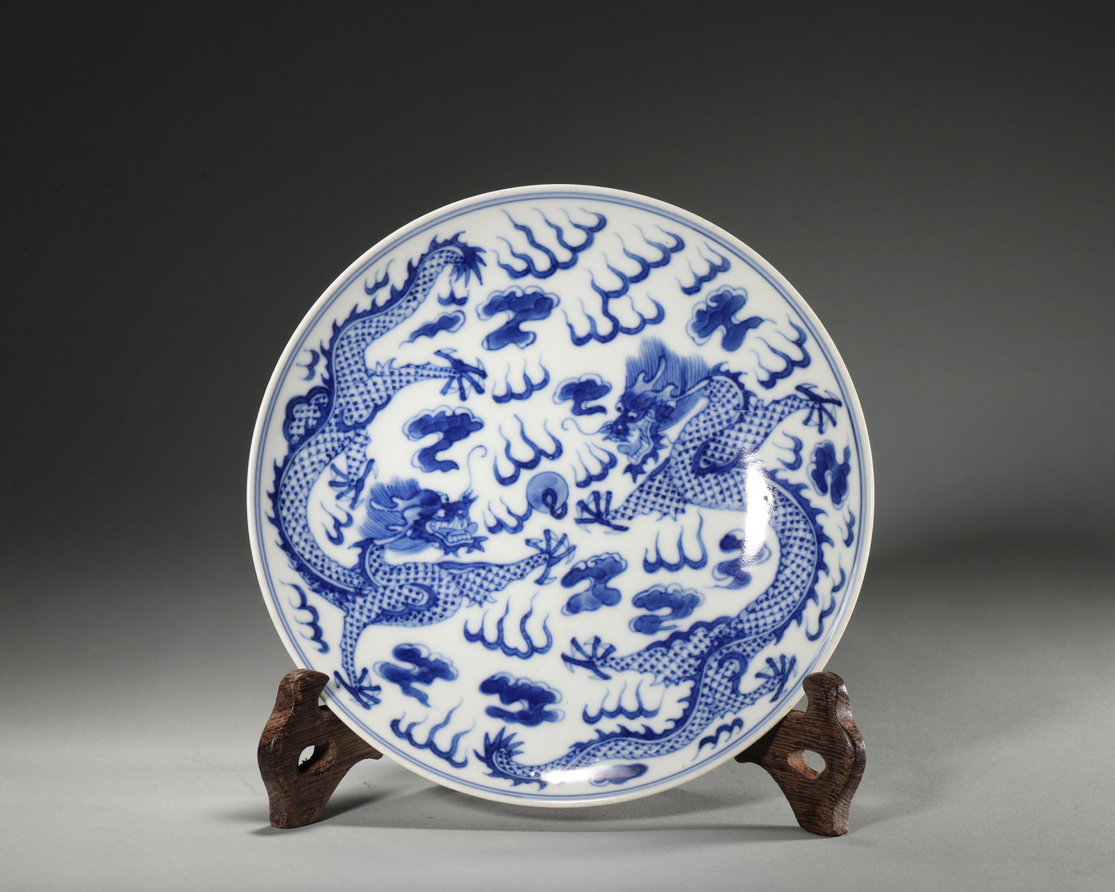 BLUE AND WHITE DISH WITH TWO DRAGONS CHASING PEARL, GUANGXU PERIOD, QING DYNASTY (1875-1908 AD): D 16.5cm (6.50 in); Wt 214g (0.47 lb),The centre painted in underglaze blue with two dragons pursuing a flaming pearl amid clouds and flames, dragon scales finely rendered. Exterior decorated with fiv