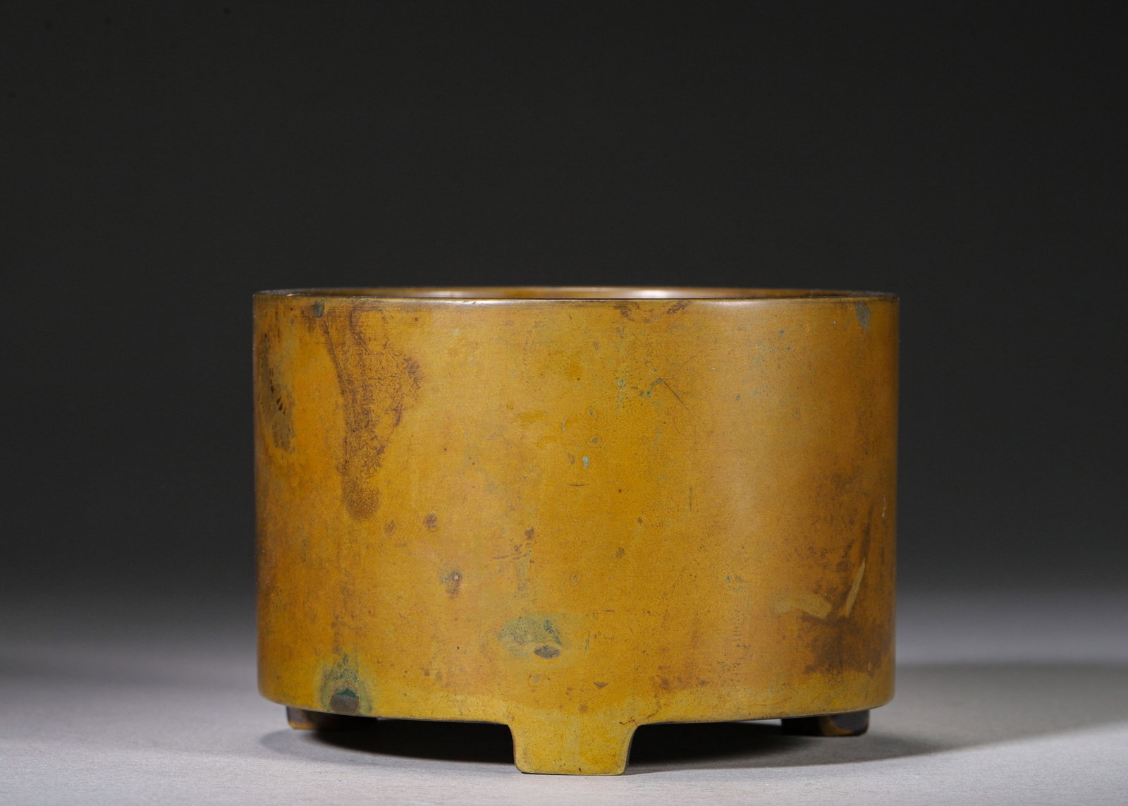 MING DYNASTY BRONZE CYLINDRICAL TRIPOD CENSER, MARK "DA MING XUANDE NIAN ZHI??: D 9.5cm (3.74 in); H 6cm (2.36 in); Wt 1116g (2.46 lb),Cast from fine bronze, this straight cylindrical censer features open mouth and plain vertical walls without ornament, supported by three square 