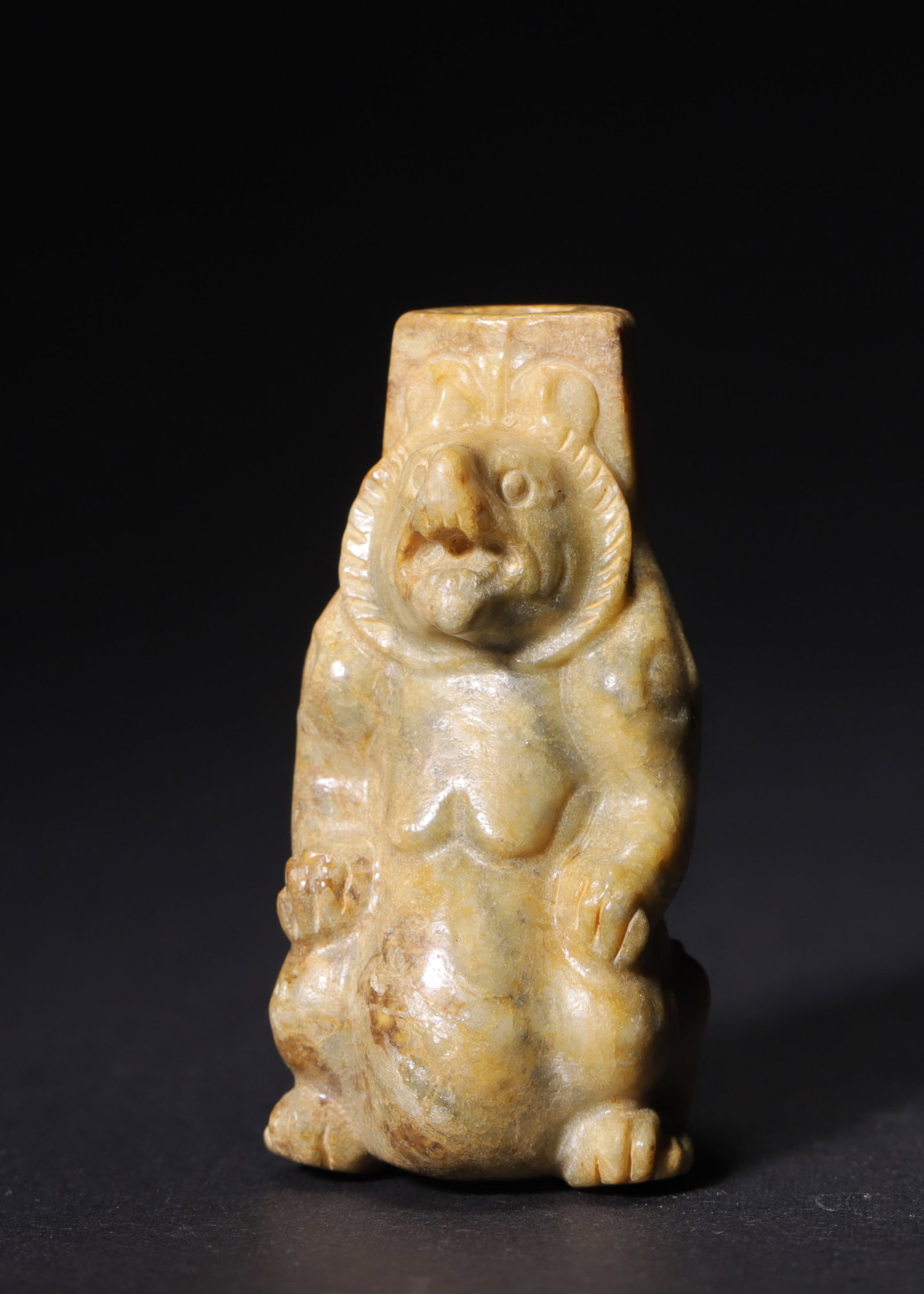 JADE BEAR CYLINDER PENDANT, HAN DYNASTY (202 BC-220 AD): H 5.6cm (2.20 in); L 2.6cm (1.02 in); W 2.4cm (0.94 in),Hetian jade, suffused with yellowish-brown patina. Fully carved recumbent bear with open mouth, stocky and powerful form rendered in succinct ca
