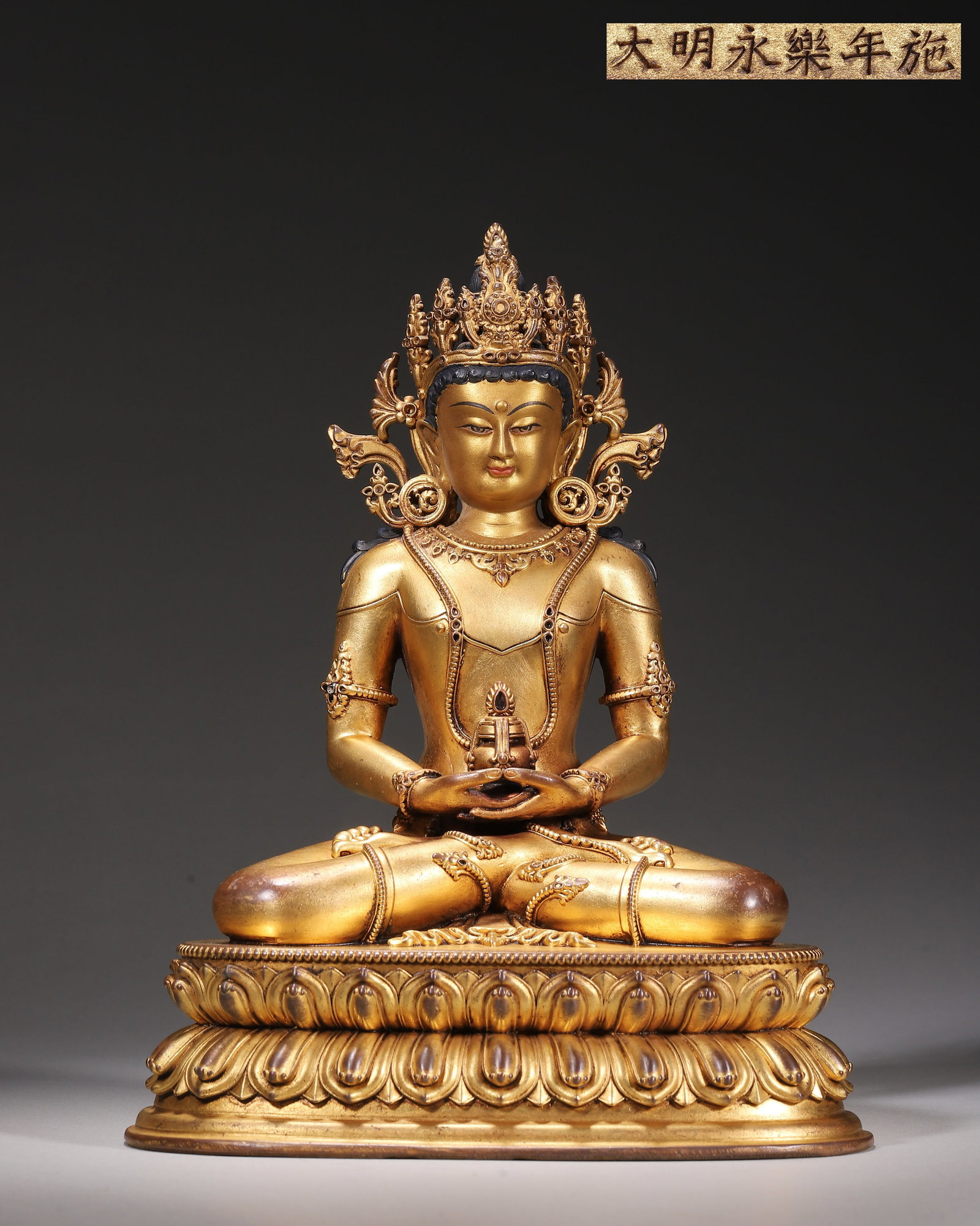 Gilt Bronze Seated Amitayus Buddha, Imperial Court Made,Marked "Made In Yongle Reign Of Great: Wt 1724g (3.801 lb),L 17cm (6.69 in),W 13cm (5.12 in),H 22cm (8.66 in)Imperial court made.The Buddha sits in padmasana beneath an ornate crown. Hands rest in dhyana mudra at the abdomen, holding the l
