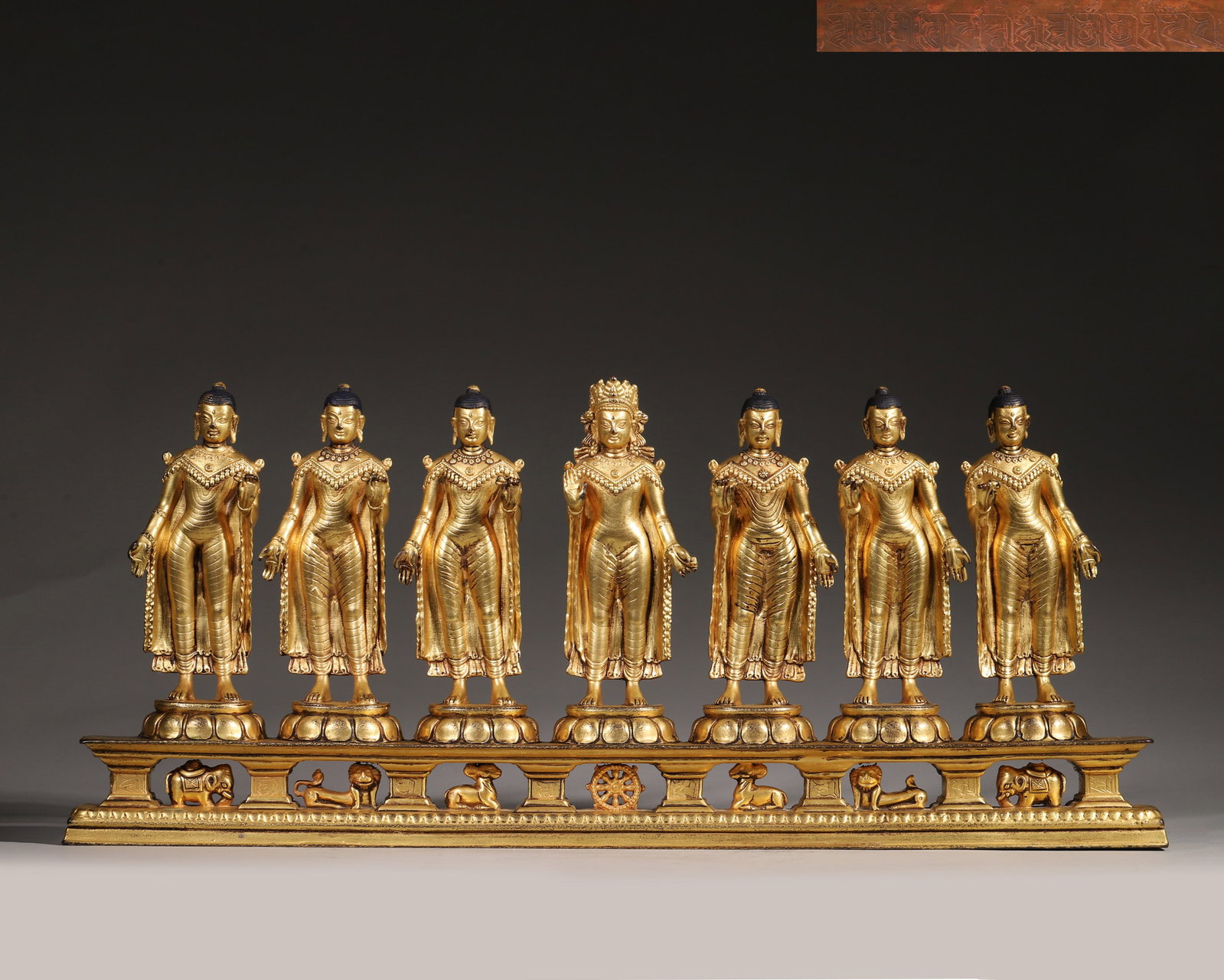 A Gilt Copper Group Statue Of The Seven Buddhas, Qing Dynasty: L 48cm (18.9 in); W 5cm (1.97 in); H 20cm (7.87 in); Wt 4558g (10.05 lb)This Qing Dynasty gilt copper statue depicts the Seven Buddhas, with Vairocana at the center flanked by six other standing Buddh