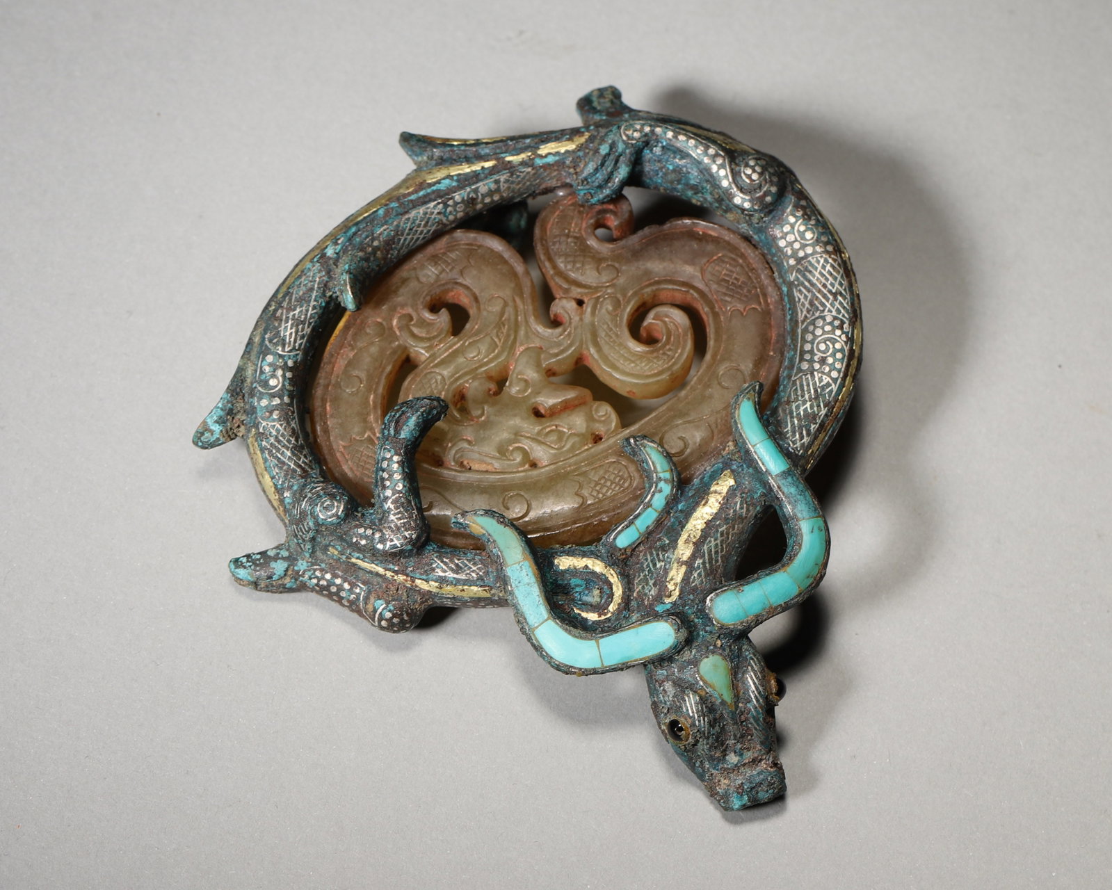 Bronze Belt Hook With Gold Silver Inlay Turquoise And Openwork Jade, Han Dynasty (202Bc 220Ad): Wt 215g (0.47 lb); L 9cm (3.54 in)Bronze belt hook decorated with gold and silver inlay and turquoise. Animal form hook head, inlaid openwork jade dragon panel. Fine craftsmanship of elite Han garment