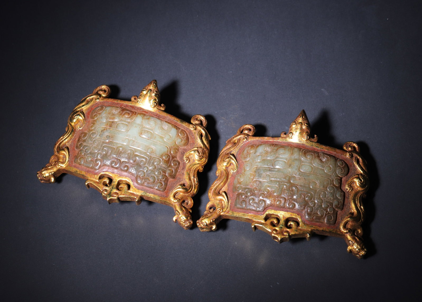Warring States Period Gilt Bronze And Jade Inlaid Belt Plaques With Beast Mask Motifs (A Pair): 5.12" x 4.33" inches (13.0 cm x 11.0 cm) | Weight: 2.69 lbs (1218.0 g)A pair of aristocratic belt plaques from the Warring States Period, featuring a gilt bronze frame inlaid with jade decorated with 