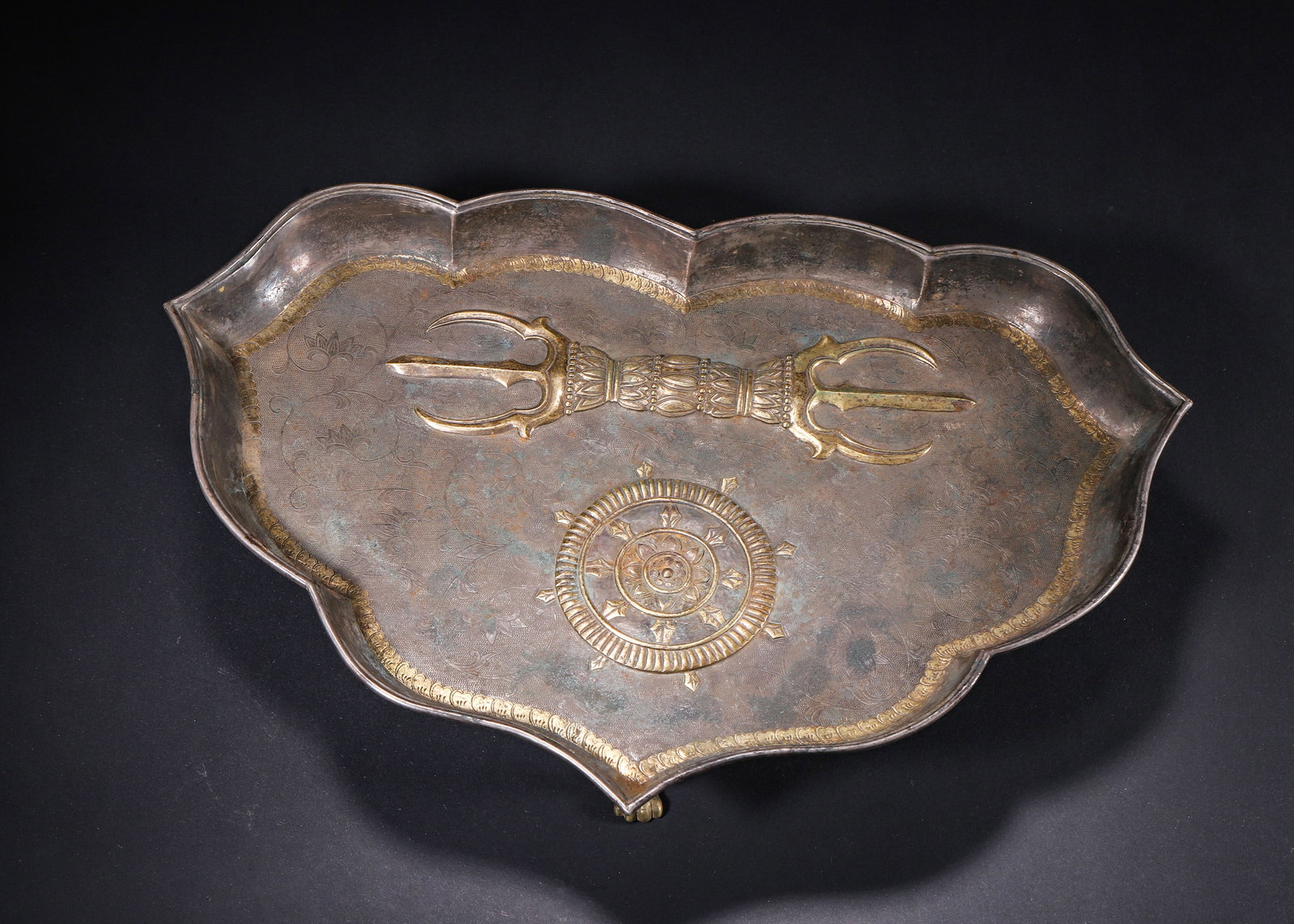 Song Yuan Period, Gilt Silver Three Legged Ritual Offering Tray With Vajra & Dharma Wheel Motifs: H 6.00cm (2.36 in); L 30.00cm (11.81 in); W 20.00cm (7.87 in); Wt 534.00g (1.18 lb)Song Yuan silver ritual tray hammered into eight lobed flower shape, supported by three gilt beast feet at base. The 