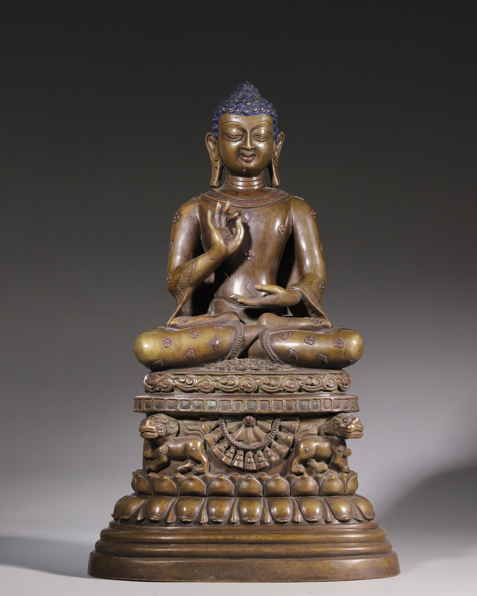 A Copper Statue Of Sakyamuni Buddha With Inlaid Red Copper, Qing Dynasty: H 35.5cm (13.98 in); L 21cm (8.27 in); W 16.5cm (6.5 in); Wt 6063g (13.37 lb)This is a Qing Dynasty copper statue of Sakyamuni Buddha inlaid with red copper. Cast in fine copper with mellow patina, th