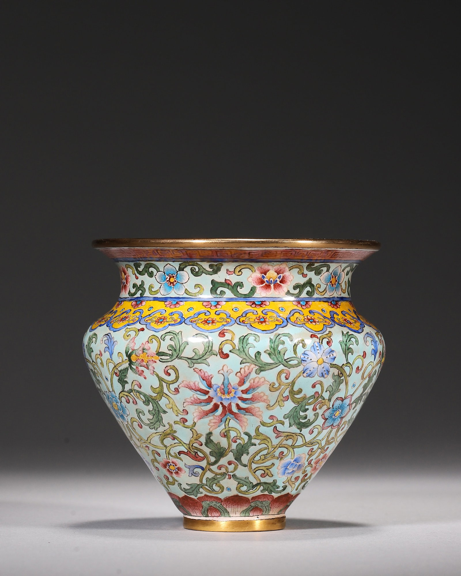 Copper Body Painted Enamel Jar With Interlocking Floral Scrolls On Pale Green Ground, Qianlong: Wt 288g (0.63 lb); D 8cm (3.15 in); H 8cm (3.15 in)Gilded rim and foot on copper body. Pale green ground painted with scrolling lotus. Multiple decorative bands at neck and lotus petal motif near base