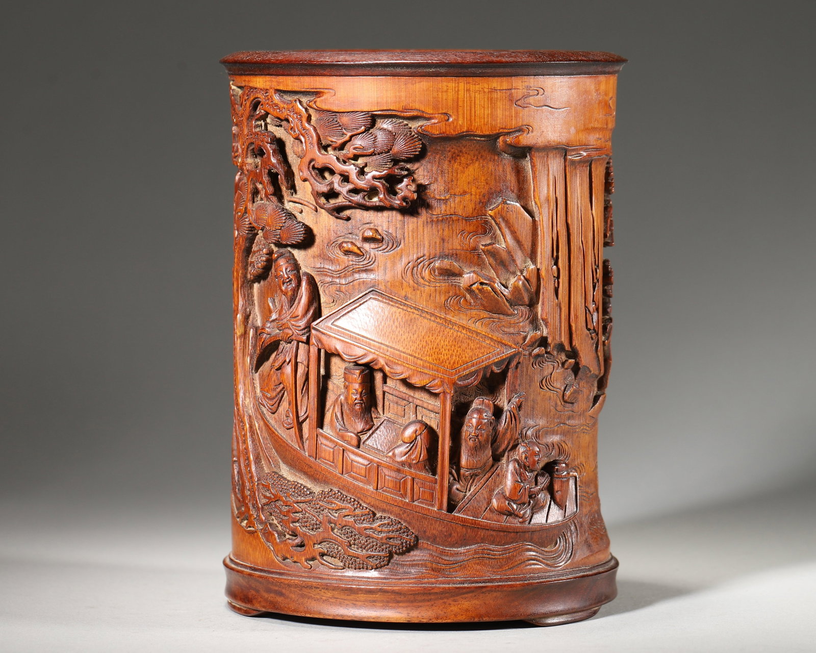 Bamboo Brush Pot With Night Tour Of Red Cliff (Qing Dynasty,1644 1912): Wt 409g (0.9017 lb); D 12cm (4.7244 in); H 16cm (6.2992 in)Bamboo brush pot fitted with hardwood rim and base. High relief carving depicts the Night Tour of Red Cliff. Figures set among pines, mountai