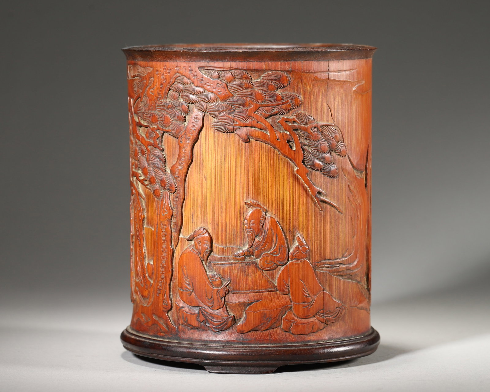 Bamboo Brush Pot With Chess Playing Scene And Poem Inscription (Qing Dynasty,1644 1912): Wt 433g (0.9546 lb); D 12cm (4.7244 in); H 14.5cm (5.7087 in)Bamboo brush pot with hardwood three foot base. Relief carving depicts scholars playing chess and tea making scene, accompanied by inscribe