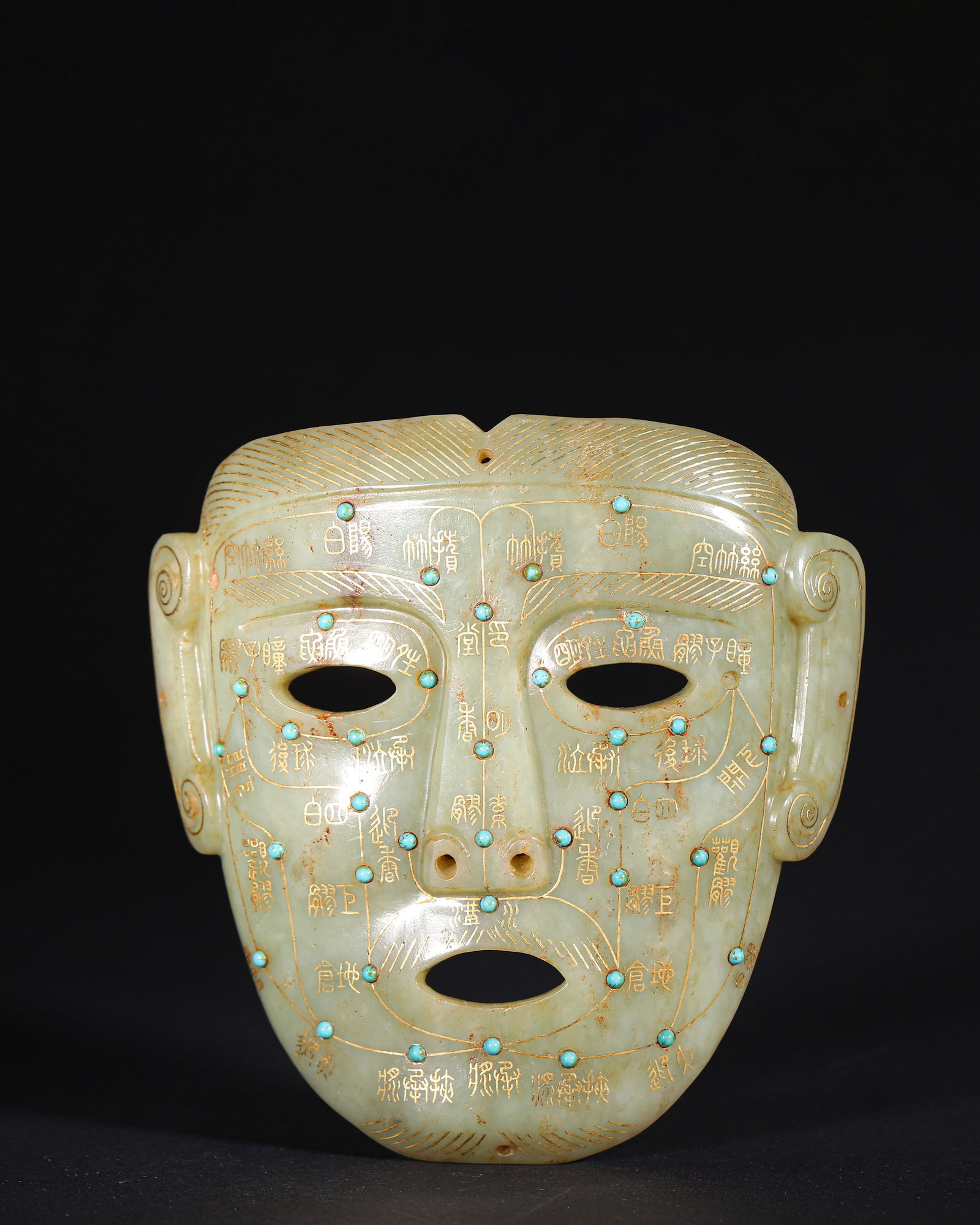 Gold Inlaid Turquoise Set Jade Mask, Han Dynasty (202 Bce 220 Ce): Wt 287g (0.63 lb); L 13cm (5.12 in); W 13cm (5.12 in)Hetian jade mask with natural patina. Gold inscriptions and meridian lines are carved on surface, inlaid with turquoise at acupoints. Pierced featu